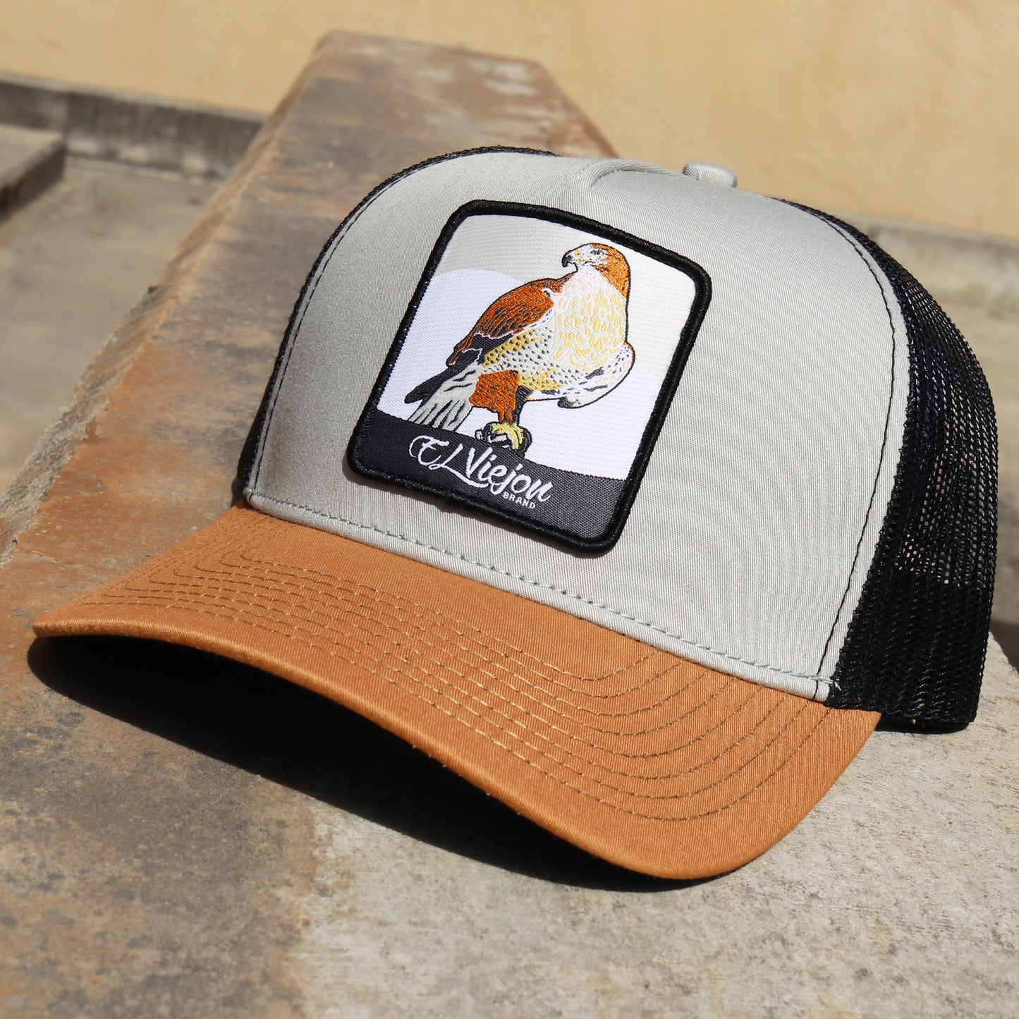Halcon Camel/Tope/Black AVC hat with falcon patch, camel brim, tope front, and black mesh back.