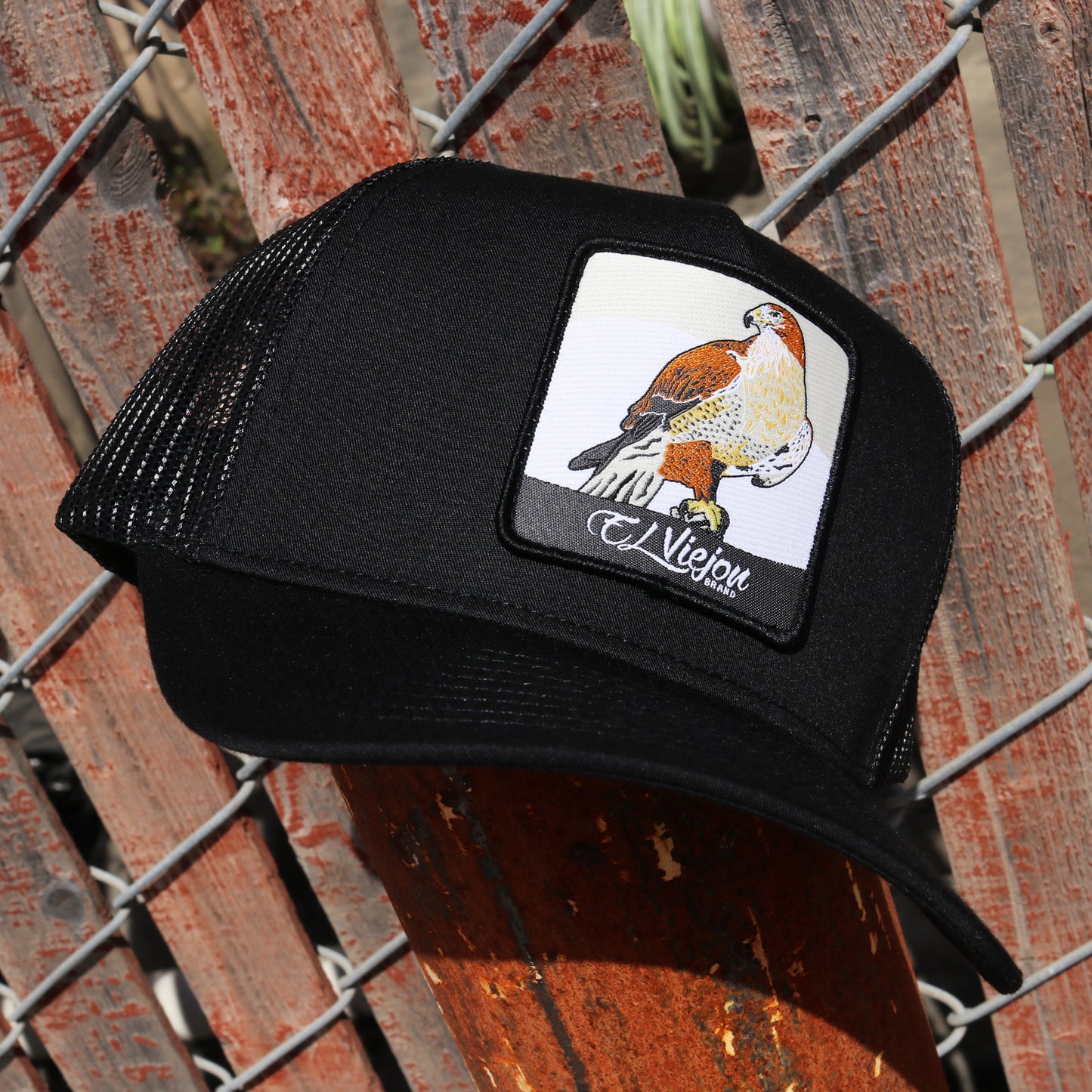 Halcon Black AVC hat with black mesh, pre-curved visor, and falcon patch.