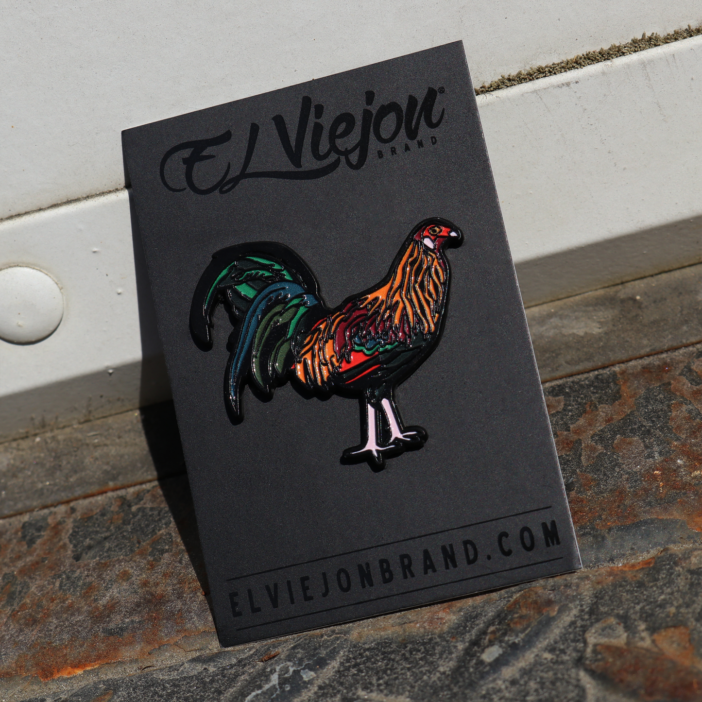 Gallo Colorado enamel pin on black card, featuring a vibrant rooster with orange, green, and black details.