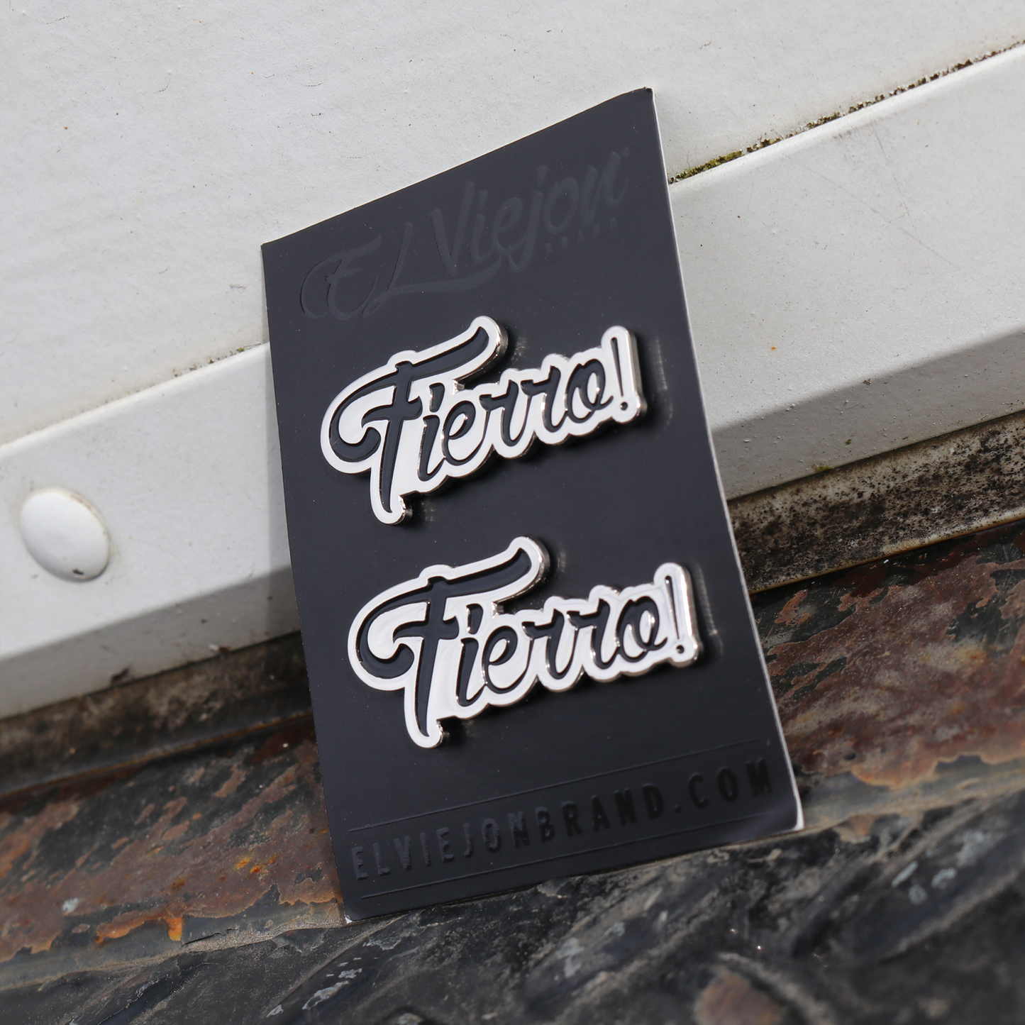 Two silver "Fierro!" script pins on a black El Viejon Brand card.