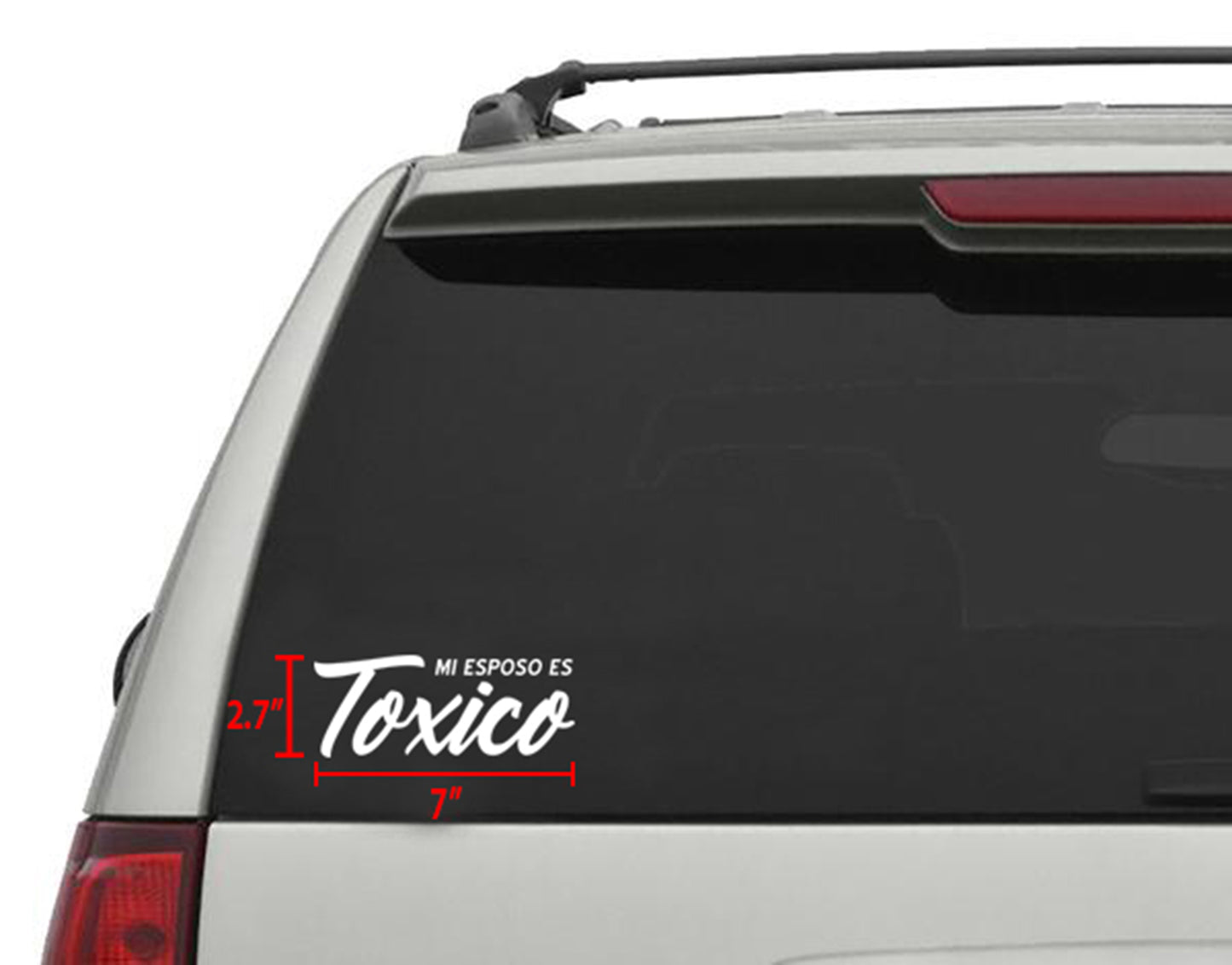 White "Mi Esposo Es Toxico" die-cut vinyl decal, 7"x 2.75", applied to a car's rear window.