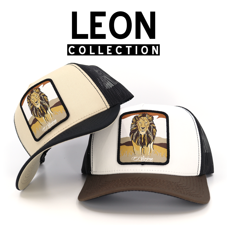 Two trucker hats from the Leon Collection, featuring a majestic lion patch on beige and white fronts.
