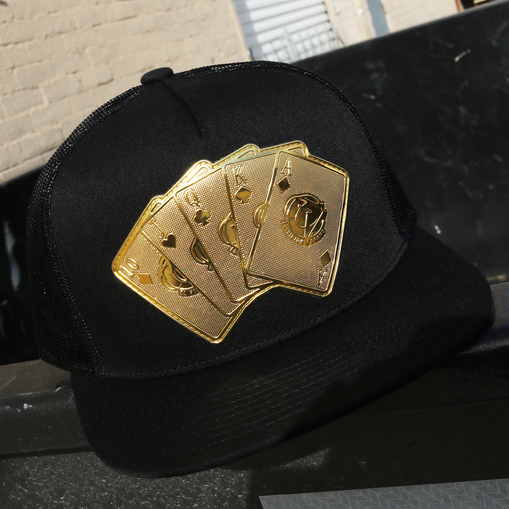 Baraja De Oro Black flat visor trucker hat with gold playing card emblem.