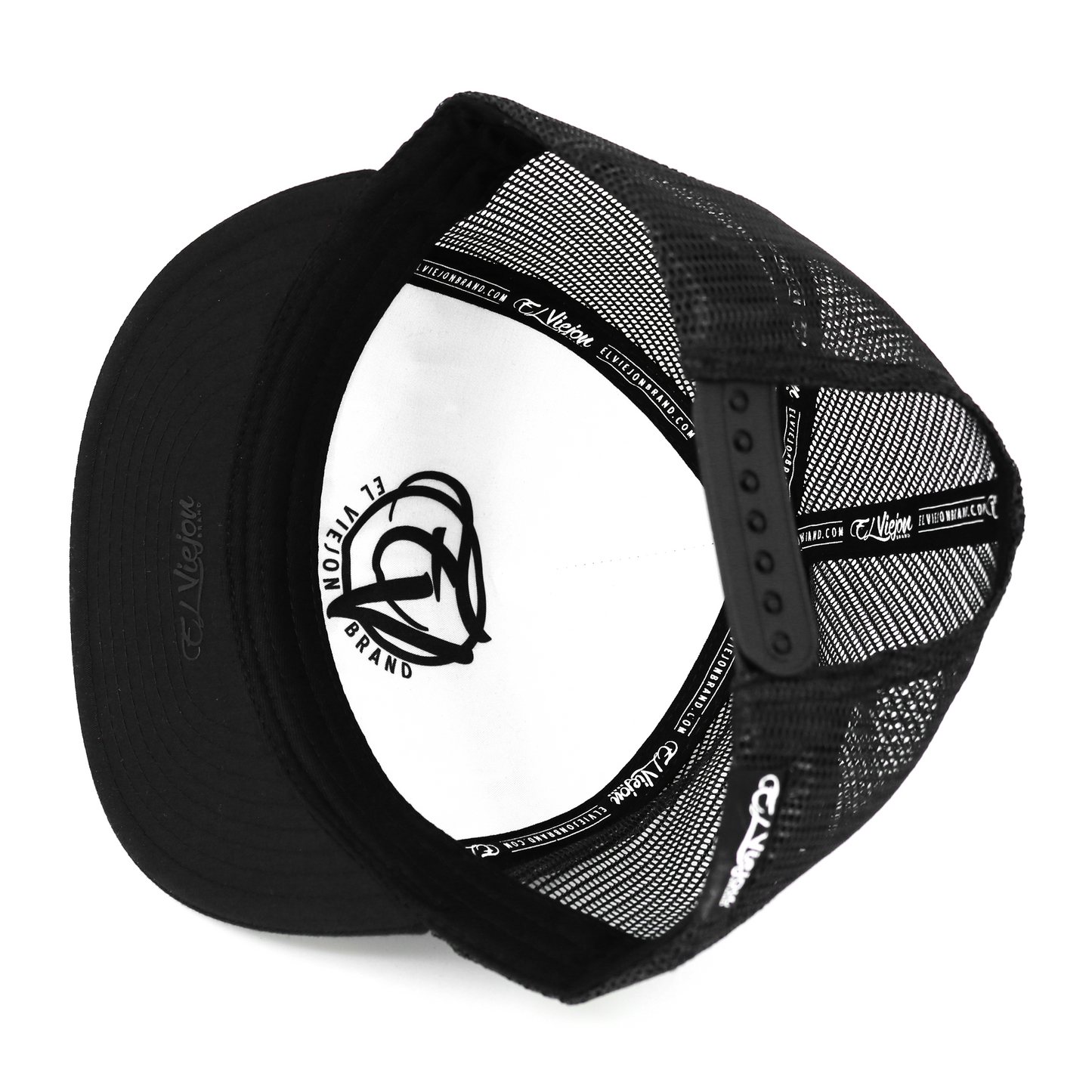 Cabron Y Vago black flat visor hat with black mesh back, adjustable snapback, and white interior branding.