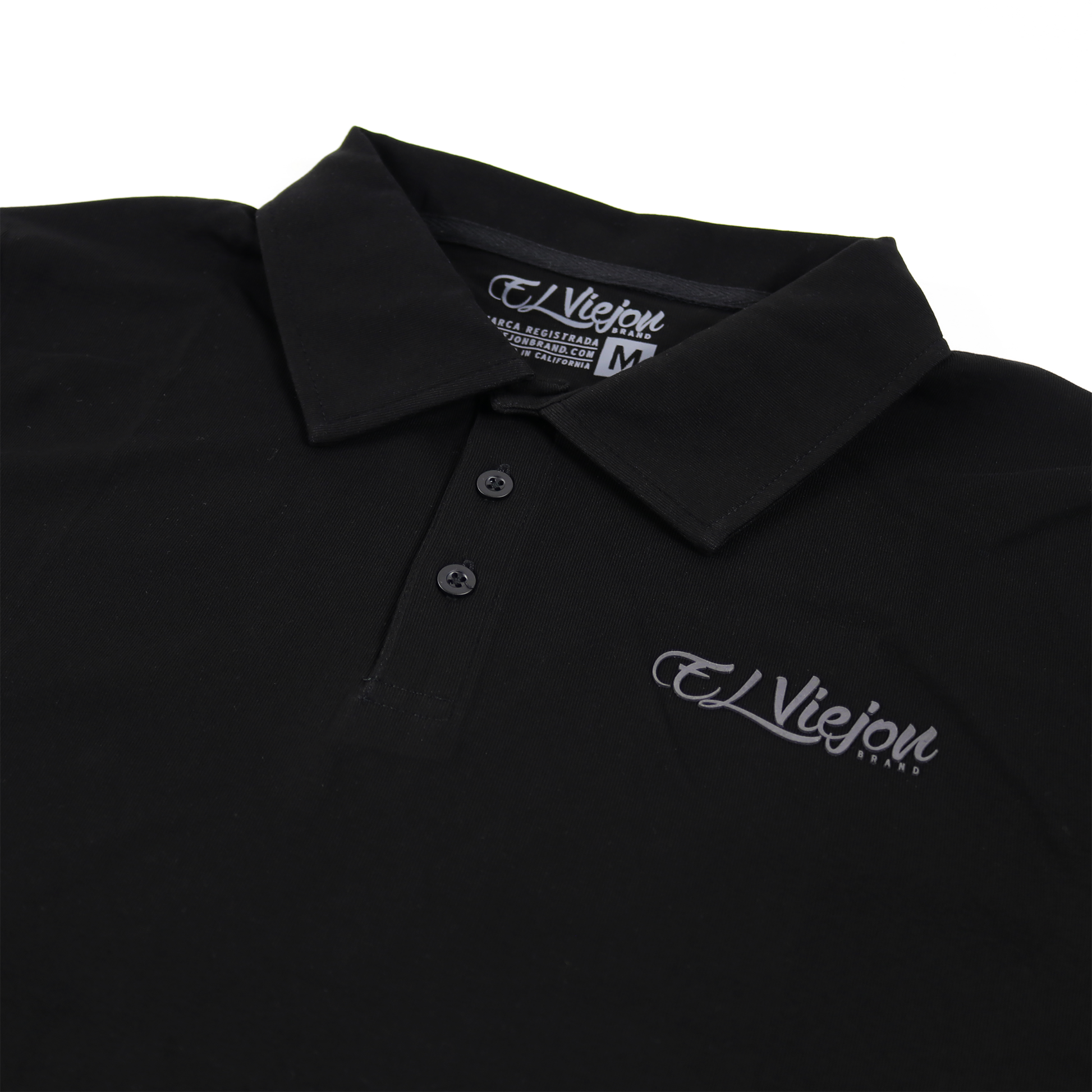 Black polo shirt with a charcoal "El Viejon Brand" 3D logo, 3-button placket, and collar.