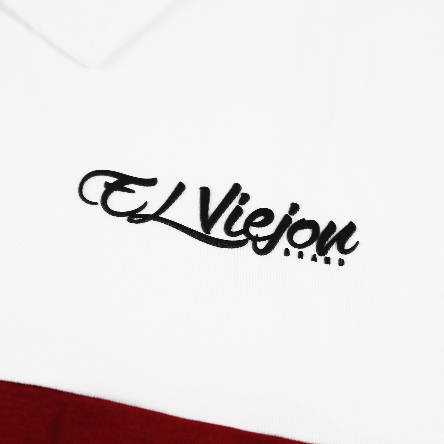 White and maroon polo shirt with a black 3D vinyl "El Viejon Brand" logo.
