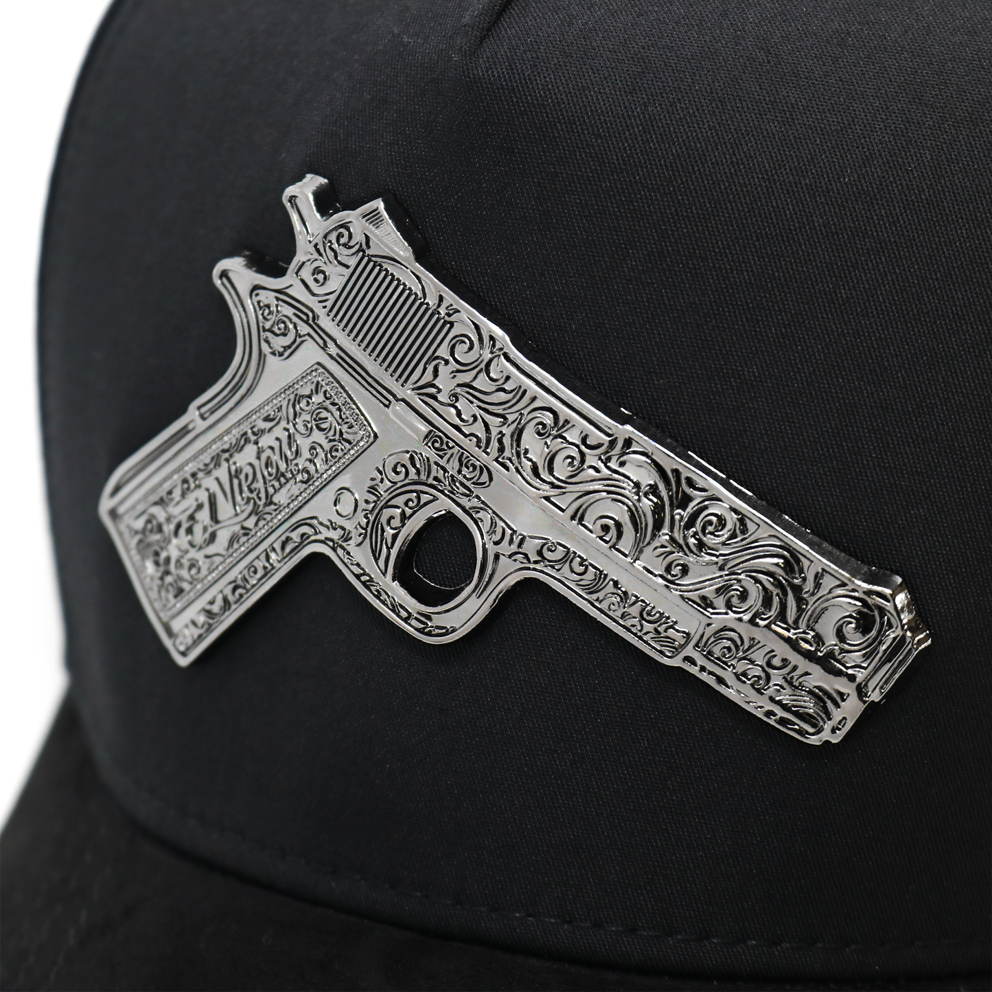 Decorative gun emblem on a black cap