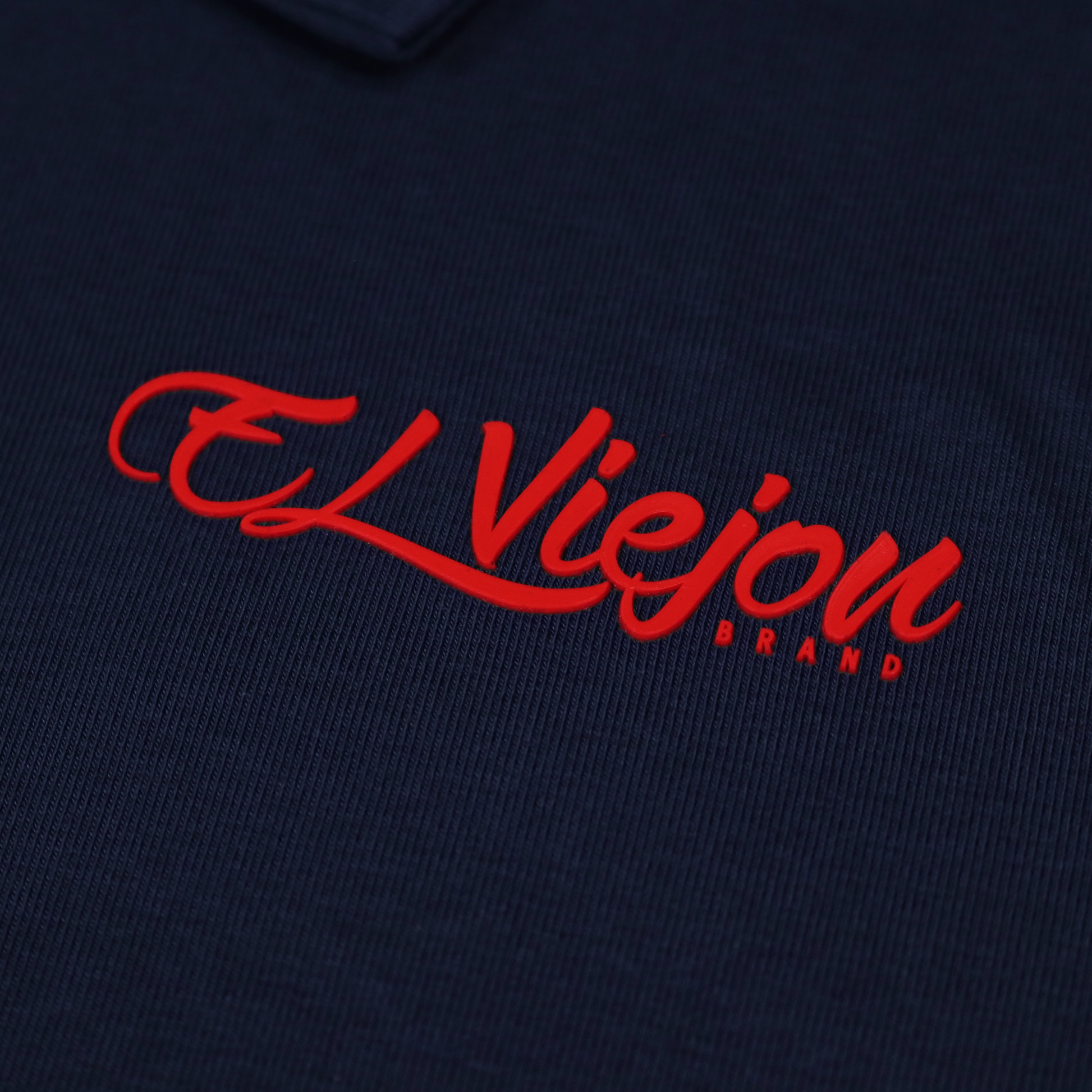 Navy blue polo shirt with a red 3D vinyl "El Viejon Brand" logo.