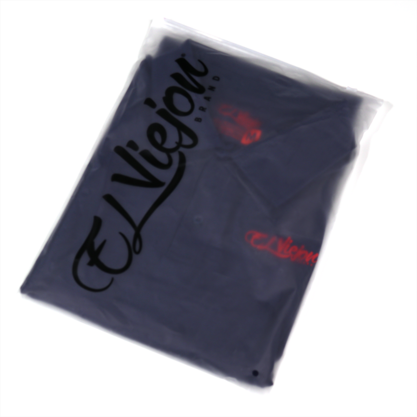 Navy blue polo shirt with 3D "El Viejon Brand" logo, packaged in clear plastic.