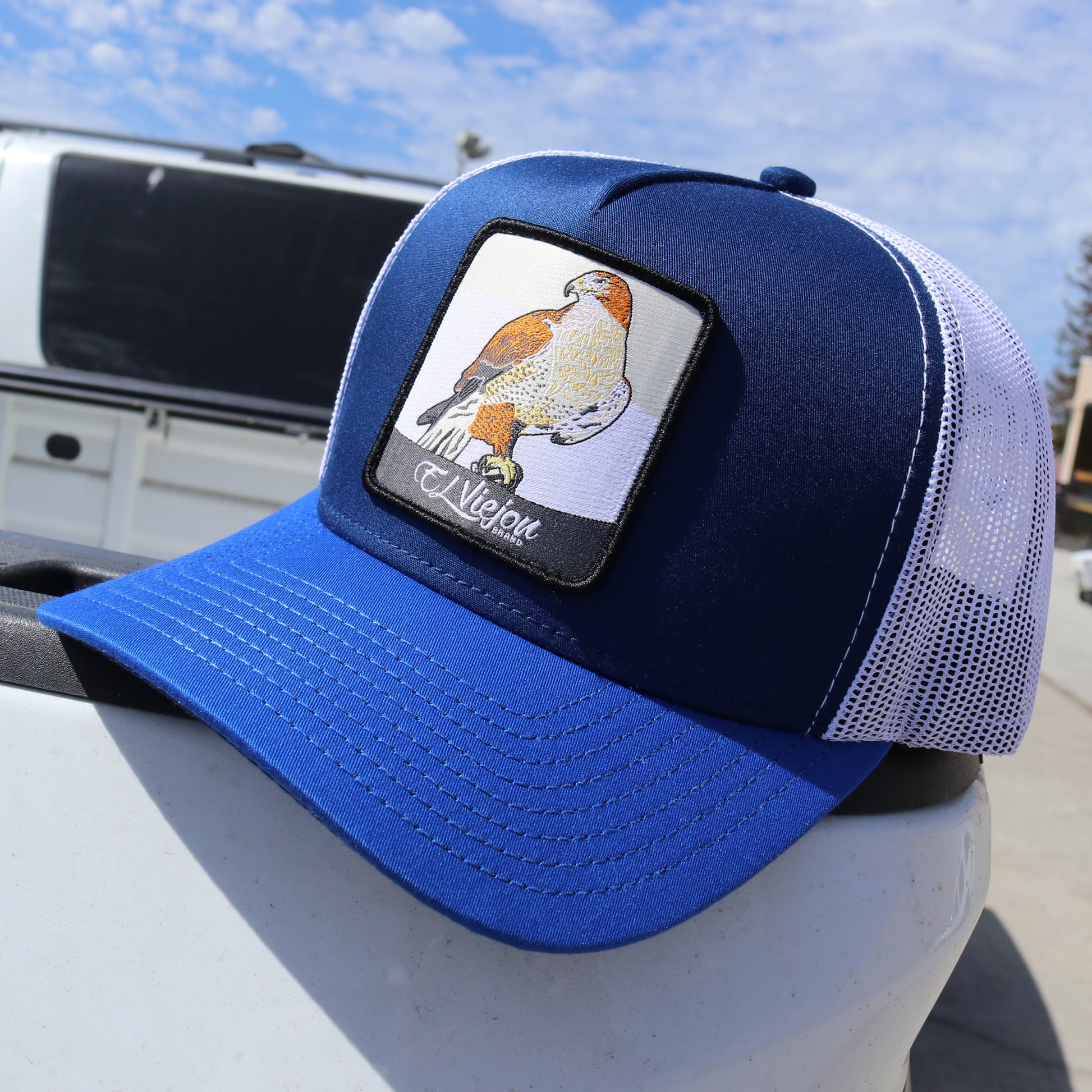 Halcon Blue/Navy/White AVC hat with a hawk patch, high profile, pre-curved visor, and white mesh back.
