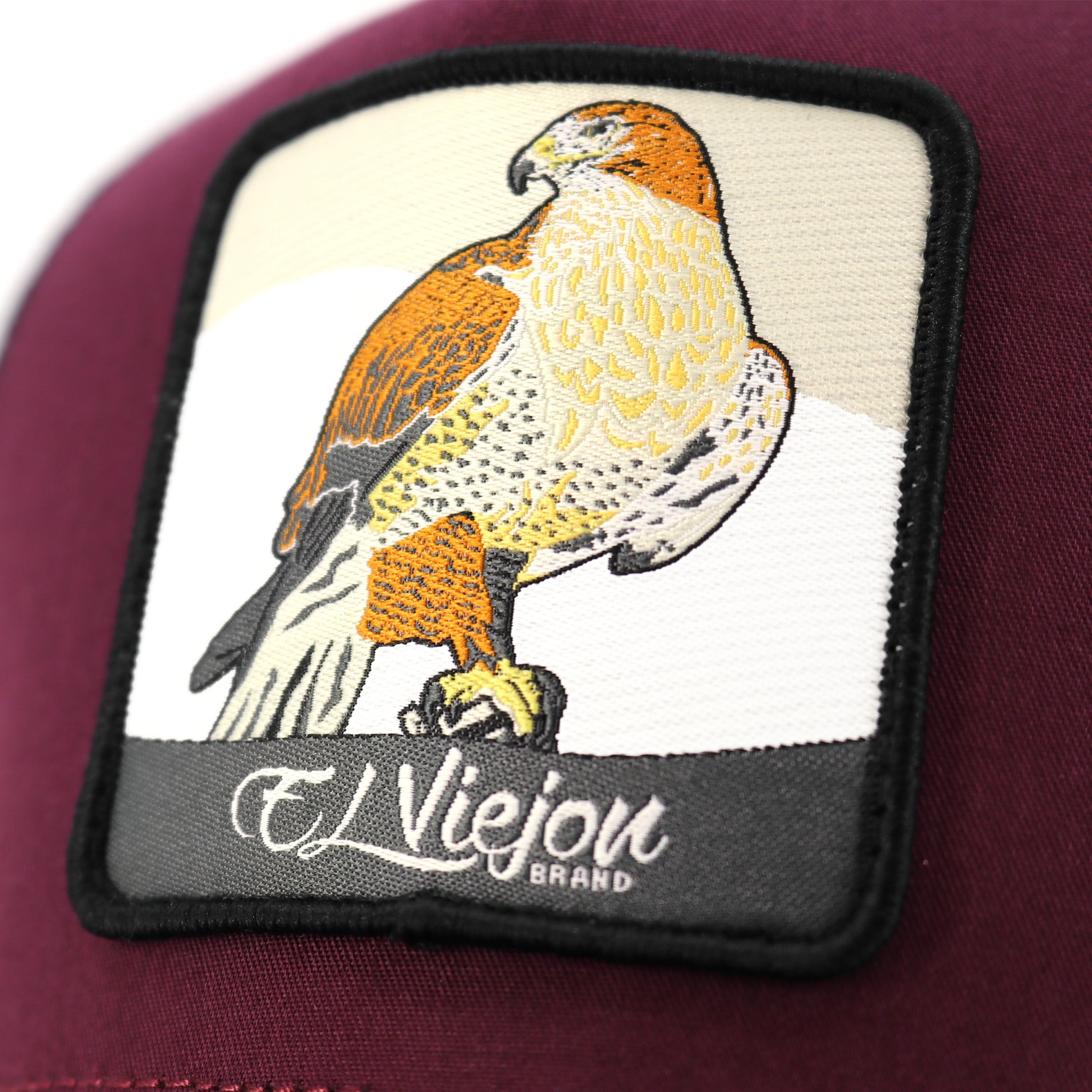 Maroon Halcon AVC hat with embroidered falcon patch and "El Viejon Brand" text.