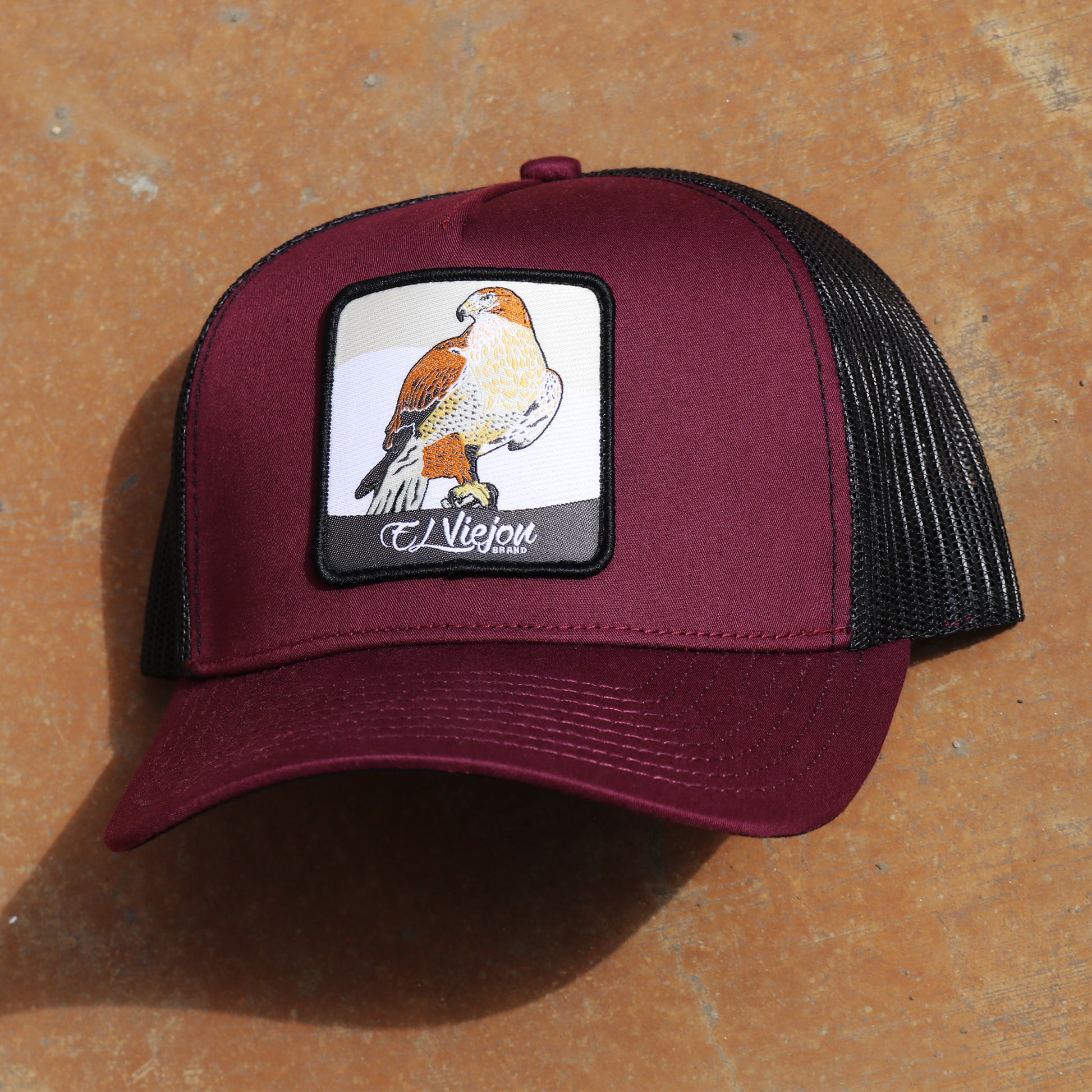 Halcon Maroon/Black AVC hat with falcon patch, pre-curved visor, and black mesh back.