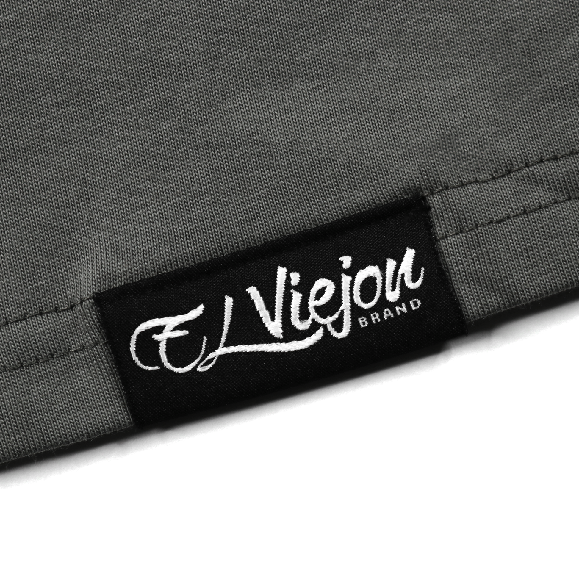 Close-up of a charcoal gray 100% cotton shirt with a black woven "El Viejou Brand" label.