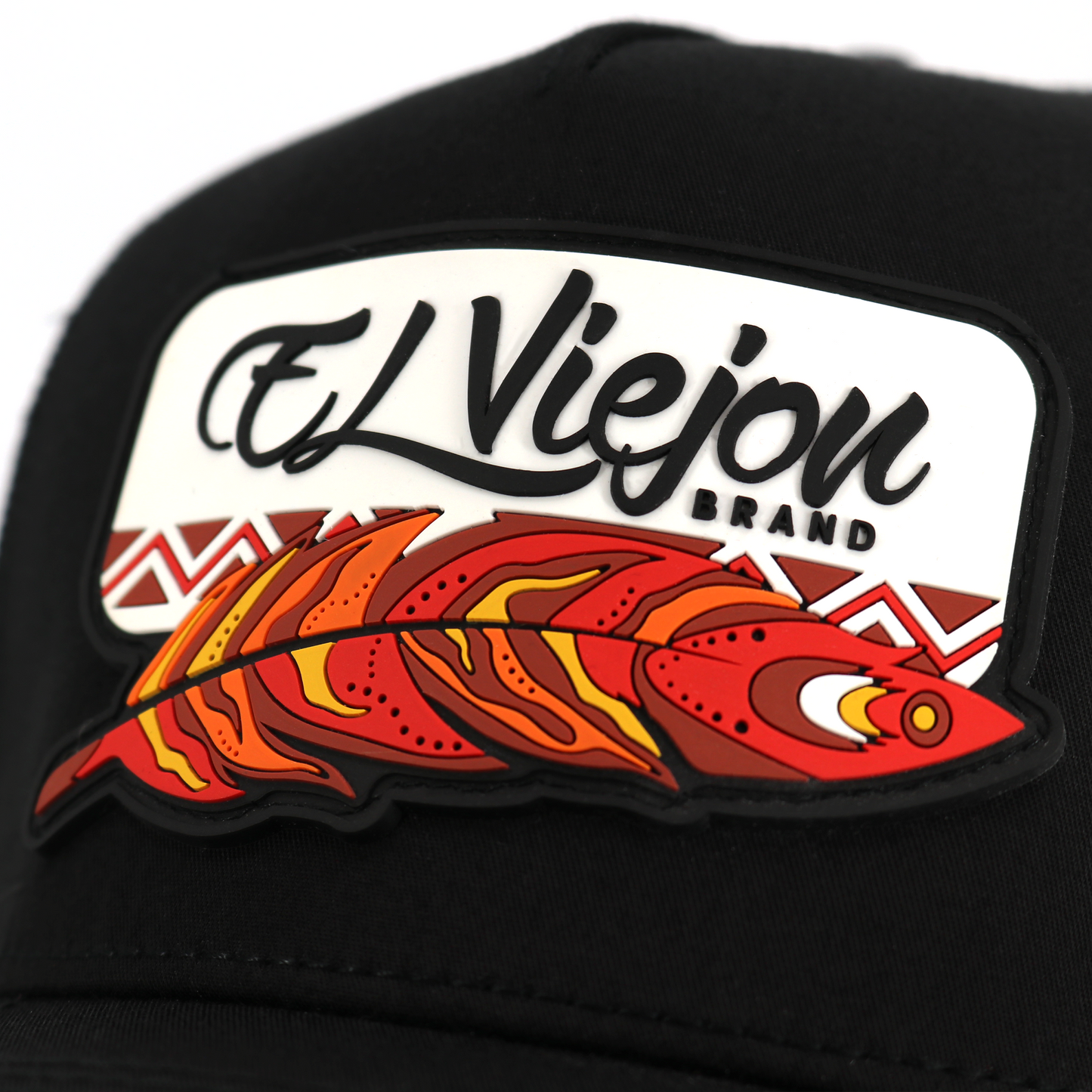 Gorra Nativo Black AVC con parche "El Viejon Brand" y pluma tribal roja, naranja y amarilla.