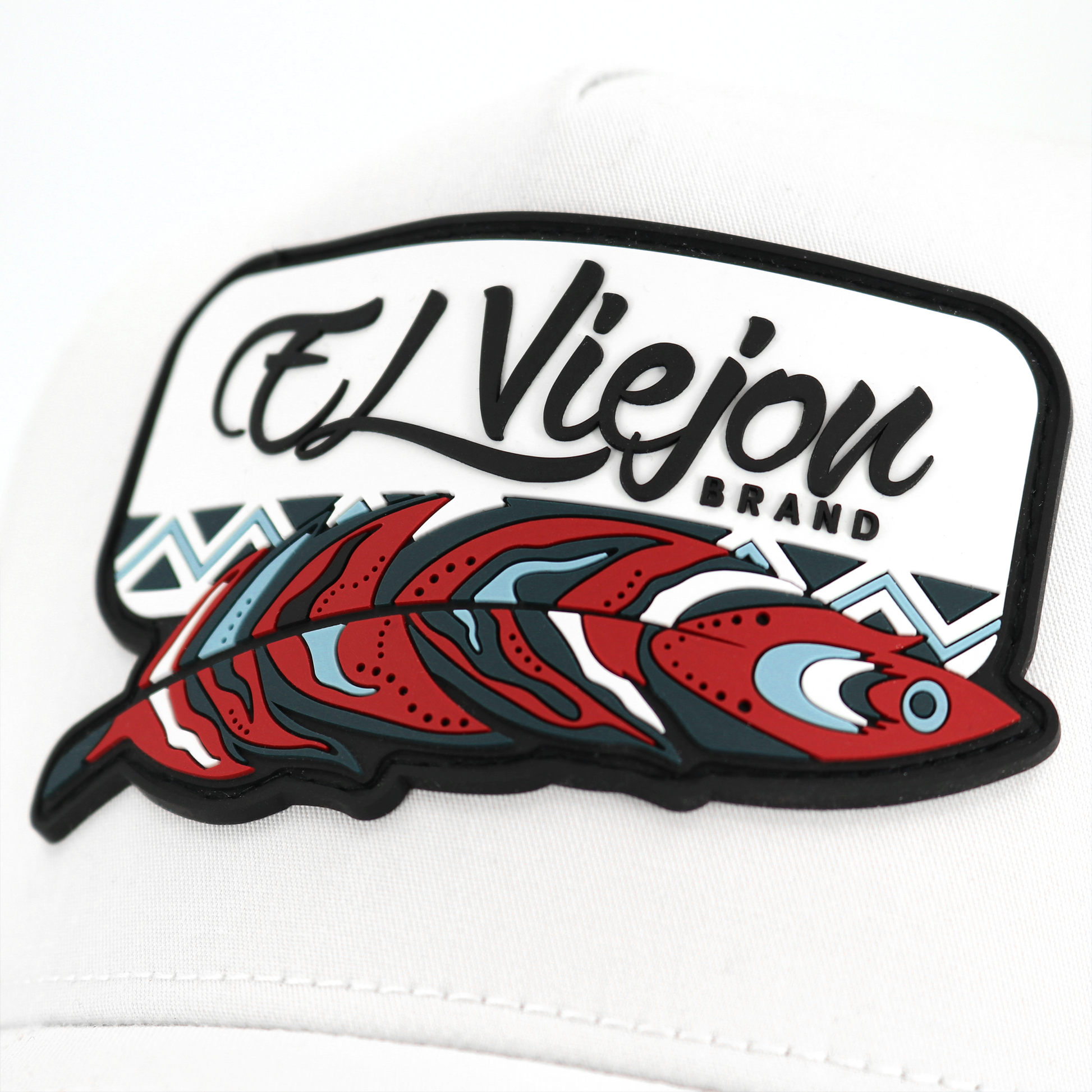 White Nativo AVC hat with "El Viejon Brand" logo and red, blue, and black feather design.