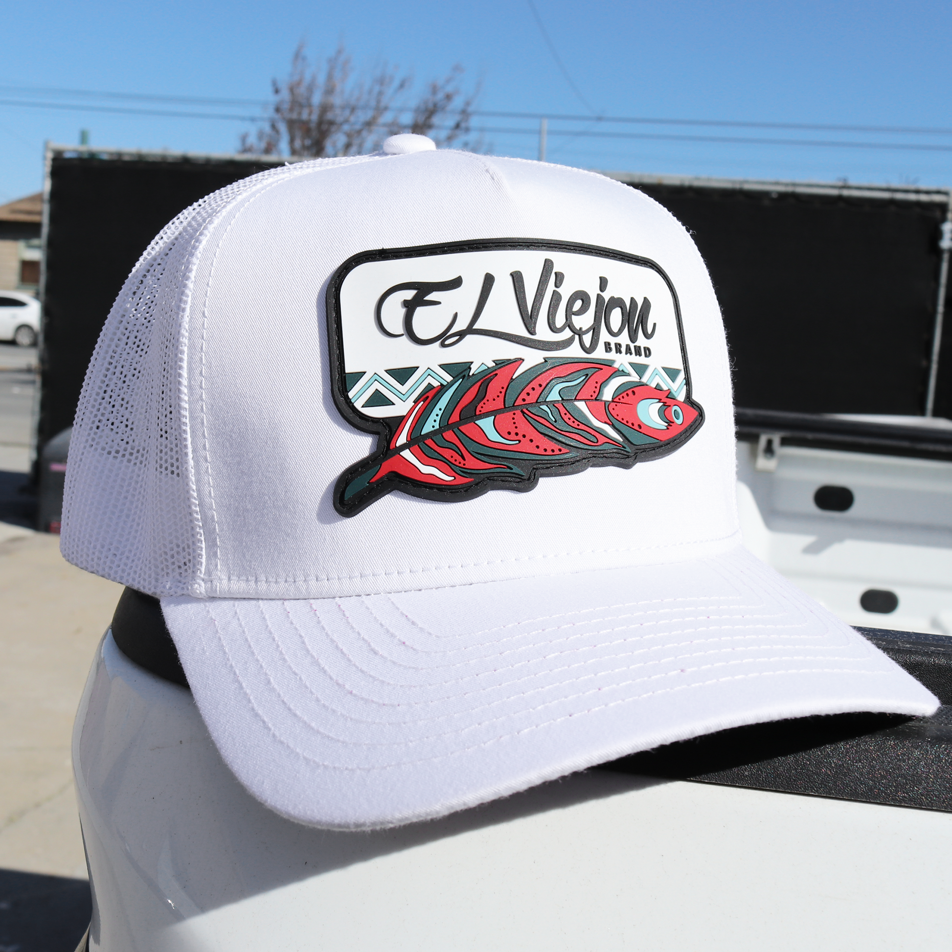 White Nativo AVC hat with white mesh back, pre-curved visor, and colorful feather logo.