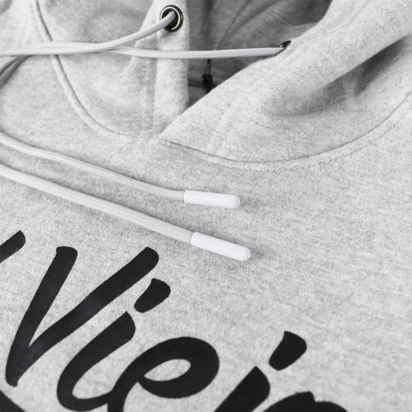 Close-up of a heather gray cotton/poly fleece hoodie with a black screen-printed logo and white drawstrings.