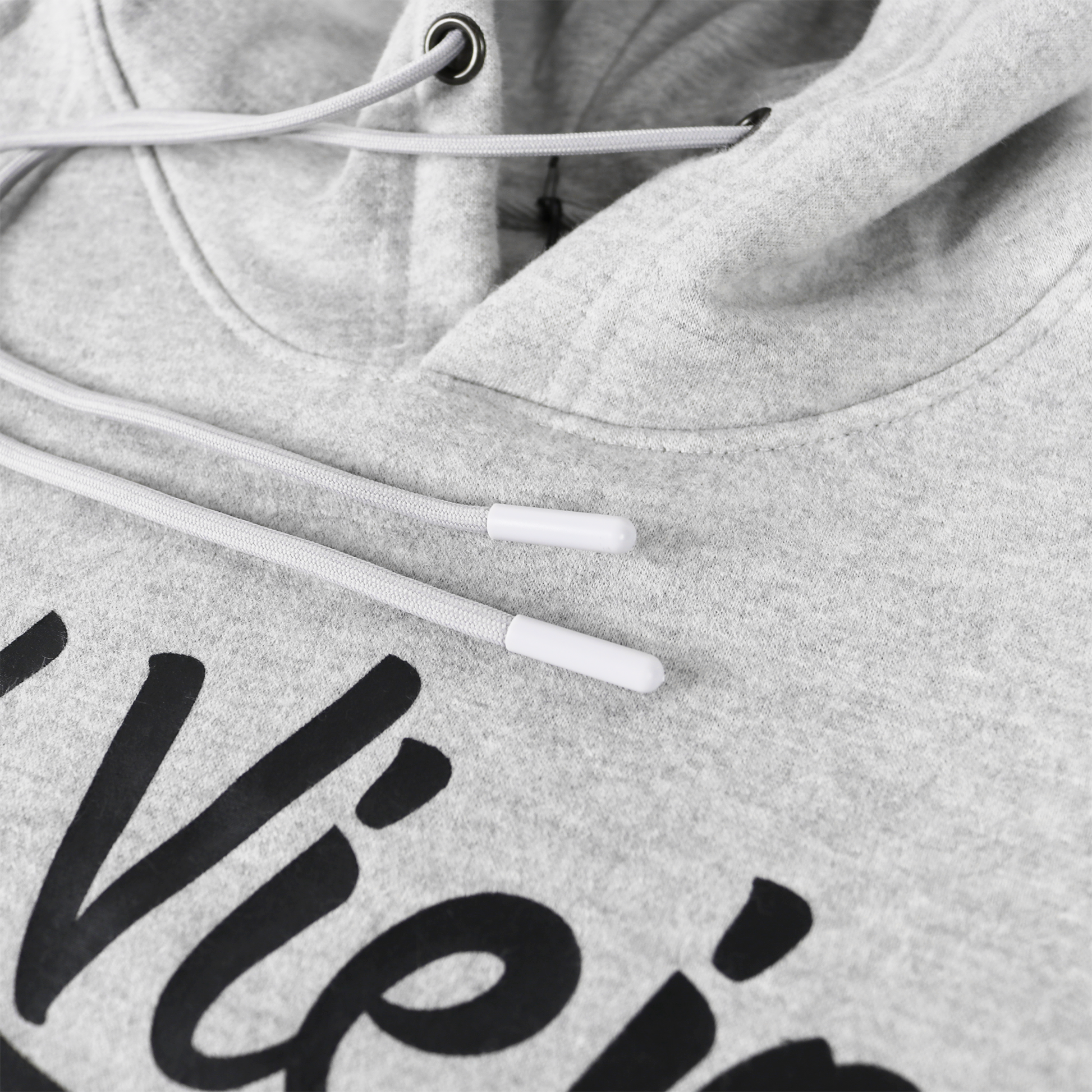 Close-up of a heather gray cotton/poly fleece hoodie with a black screen-printed logo and white drawstrings.