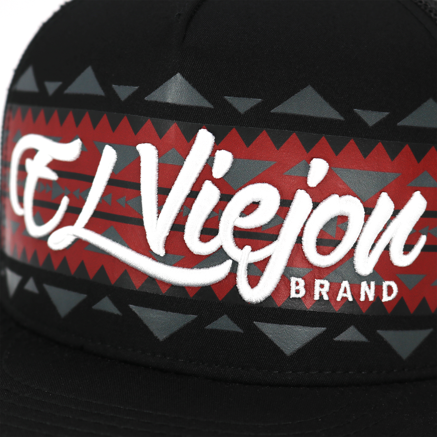 Close-up of a cap with 'El Viejo' brand logo on a geometric patterned band.