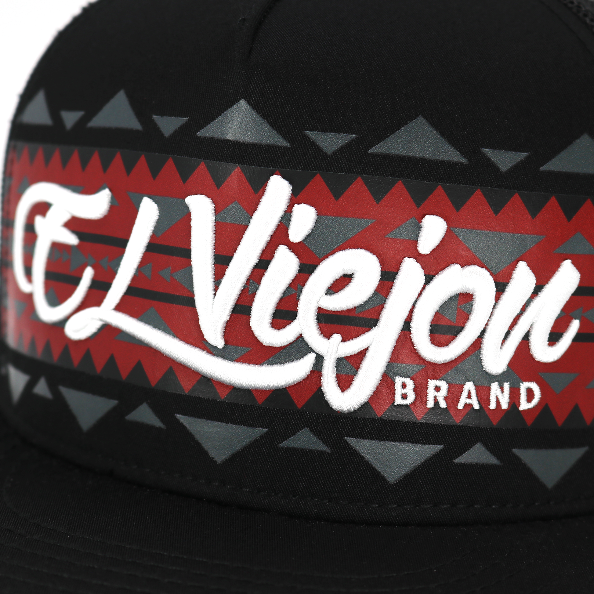 Close-up of a cap with 'El Viejo' brand logo on a geometric patterned band.