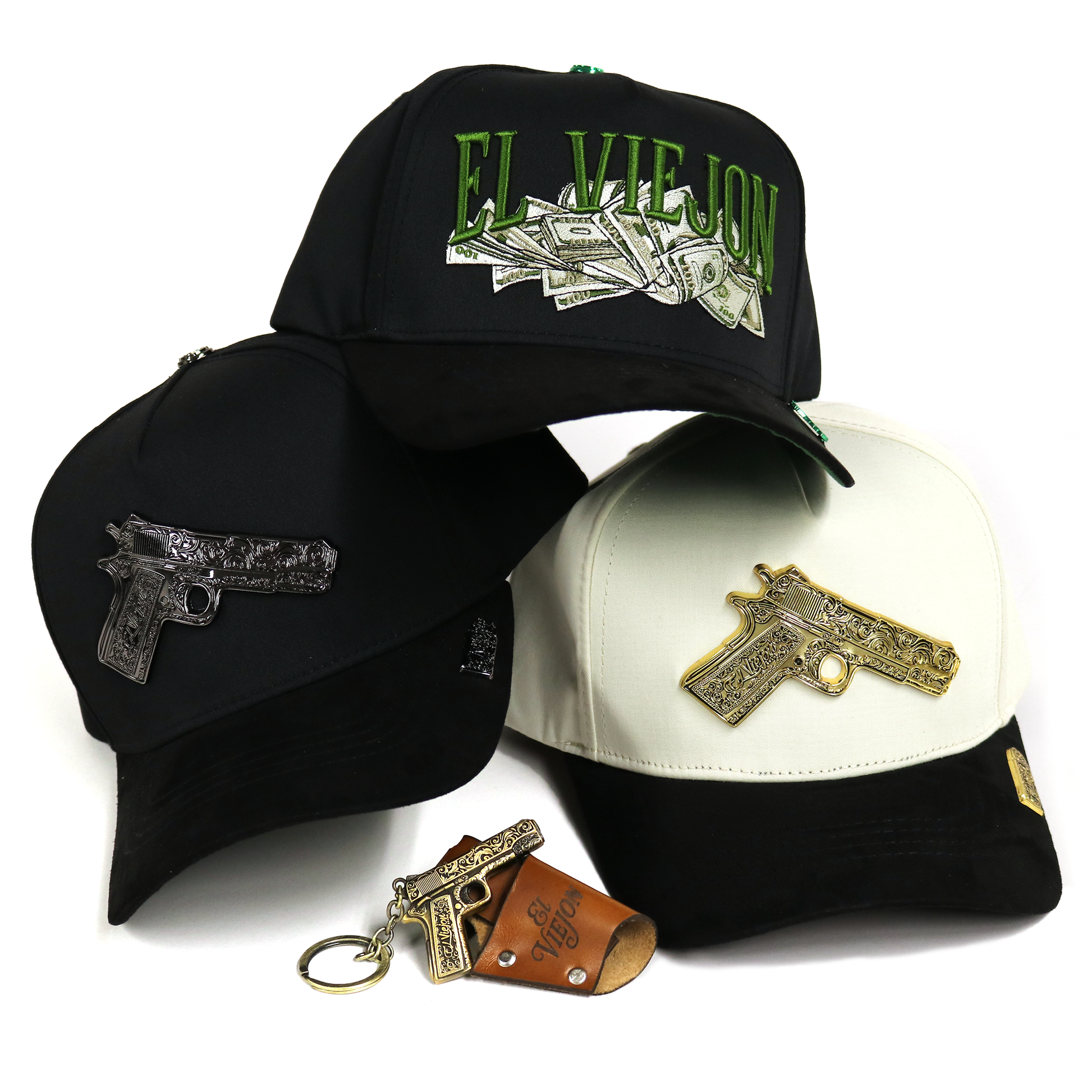 Three black baseball caps with gun-shaped metal embellishments and a matching keychain, shown on a white background. One cap has green 'EL VIEJO' text with money graphics, one is black with a silver gun emblem, and one is black and white with a gold gun emblem.