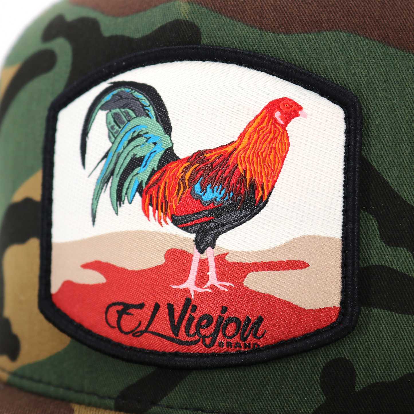 Gallo Camo/White Yupoong Classic trucker hat with embroidered rooster patch and "El Viejon" text.