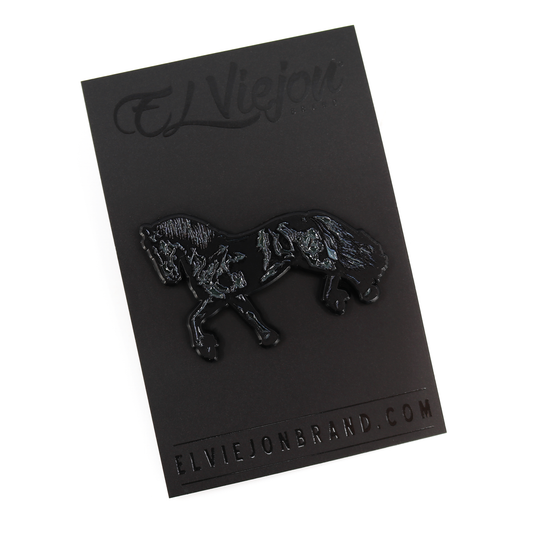 Black Frison horse enamel pin with rubber clutch on a black branded card.