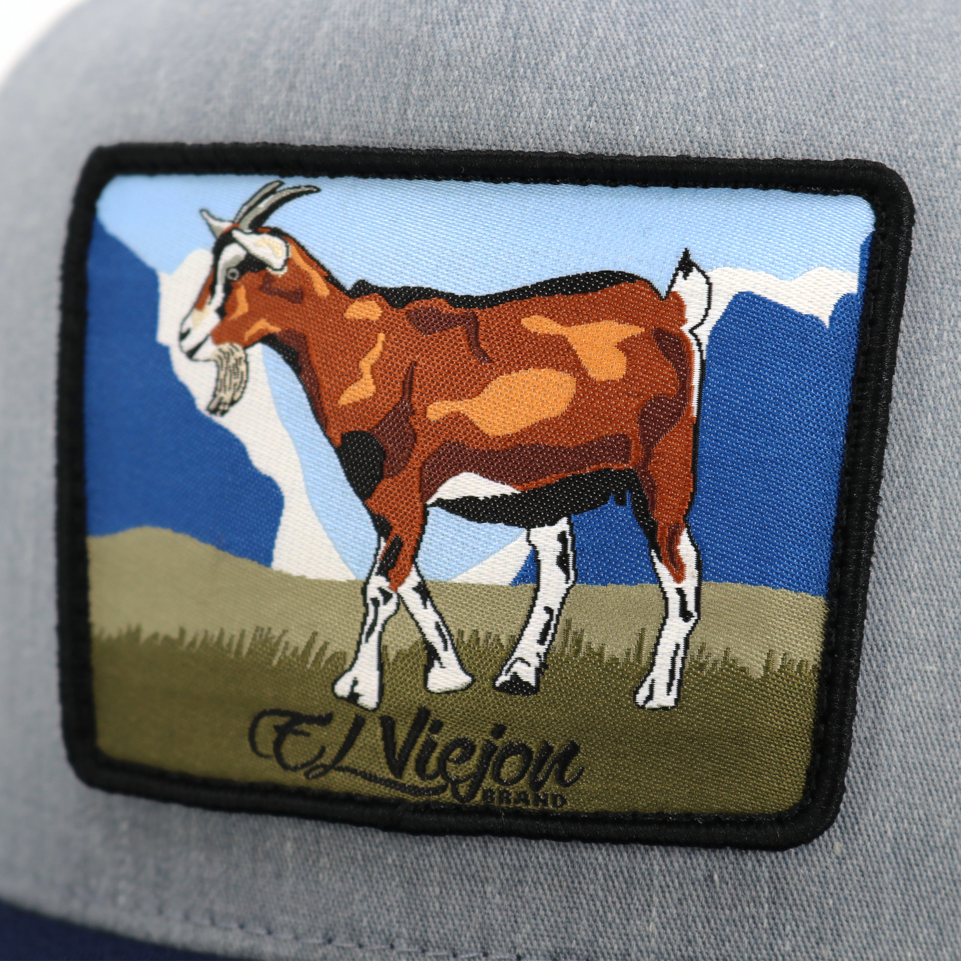 Chivo Navy/Heather/White flat visor hat with a brown goat patch and "El Viejon" text.