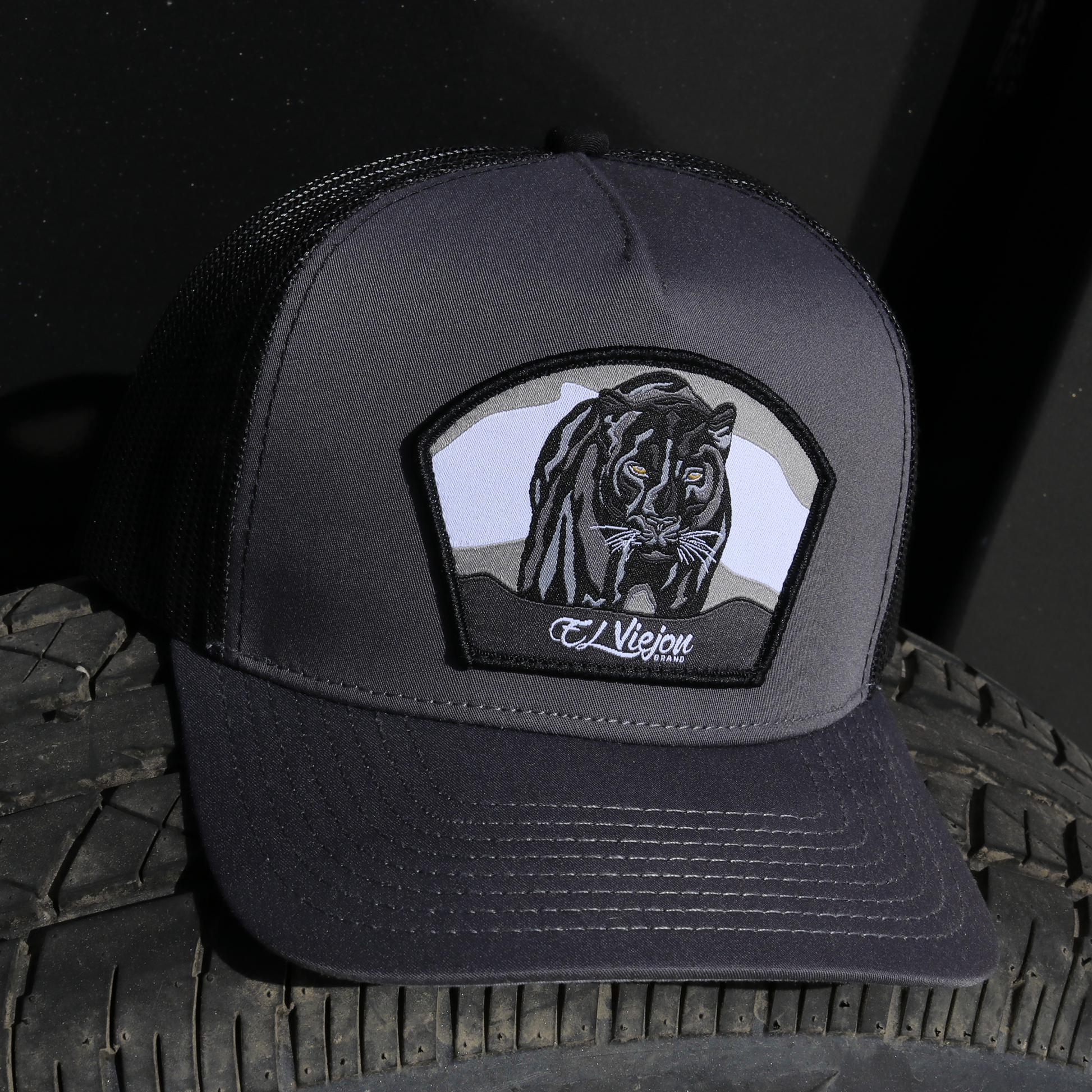 Pantera Negra charcoal/black AVC hat with black panther patch, mesh back, and snapback closure.