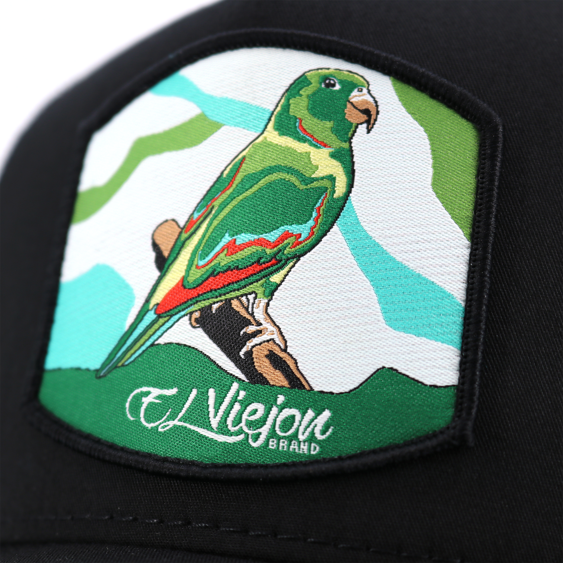 Black Perico AVC hat with embroidered green parrot patch, "El Viejon Brand" text, and white mesh.