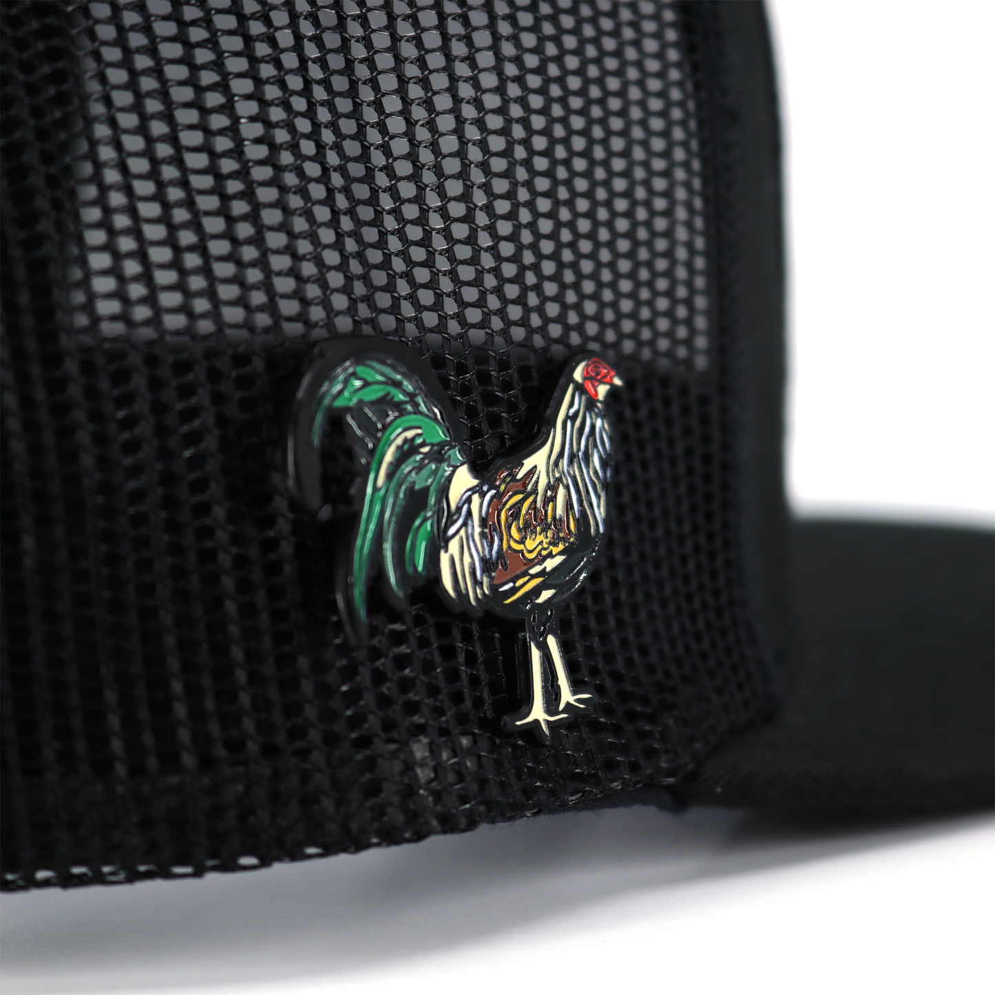 Gallo Giro enamel pin with colorful rooster design, attached to a black mesh hat.