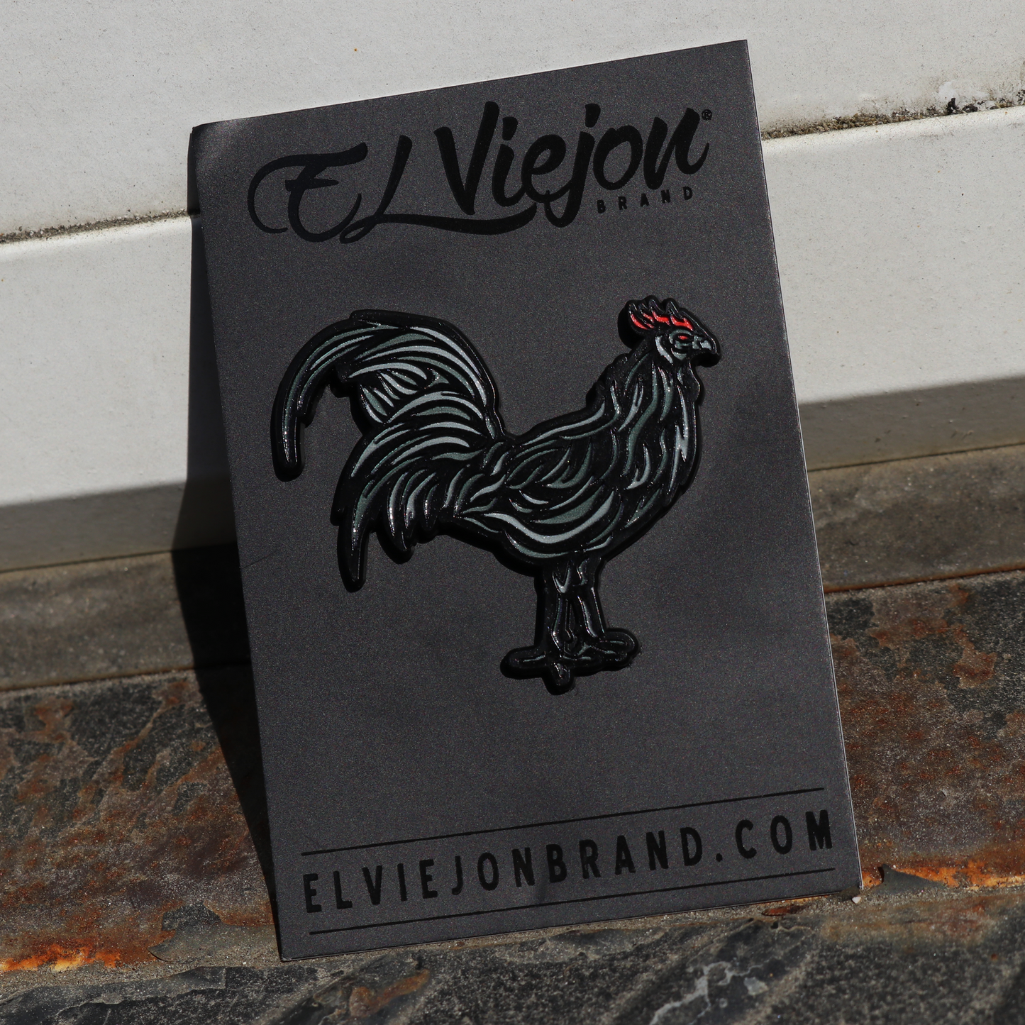 Gallo Negro enamel pin on black backing card, featuring a black rooster with red comb.