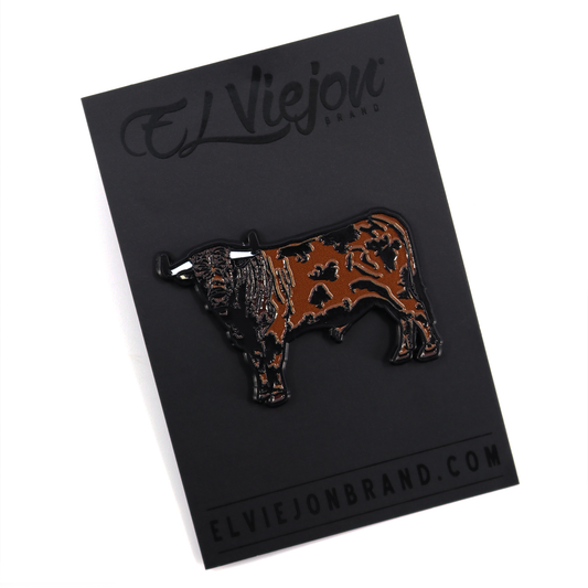 Pin esmaltado Semental de El Viejon Brand, con diseño de toro café y negro sobre tarjeta negra.