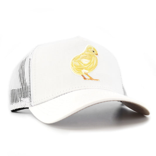White kids trucker hat with a yellow chick graphic, curved visor, and mesh back.