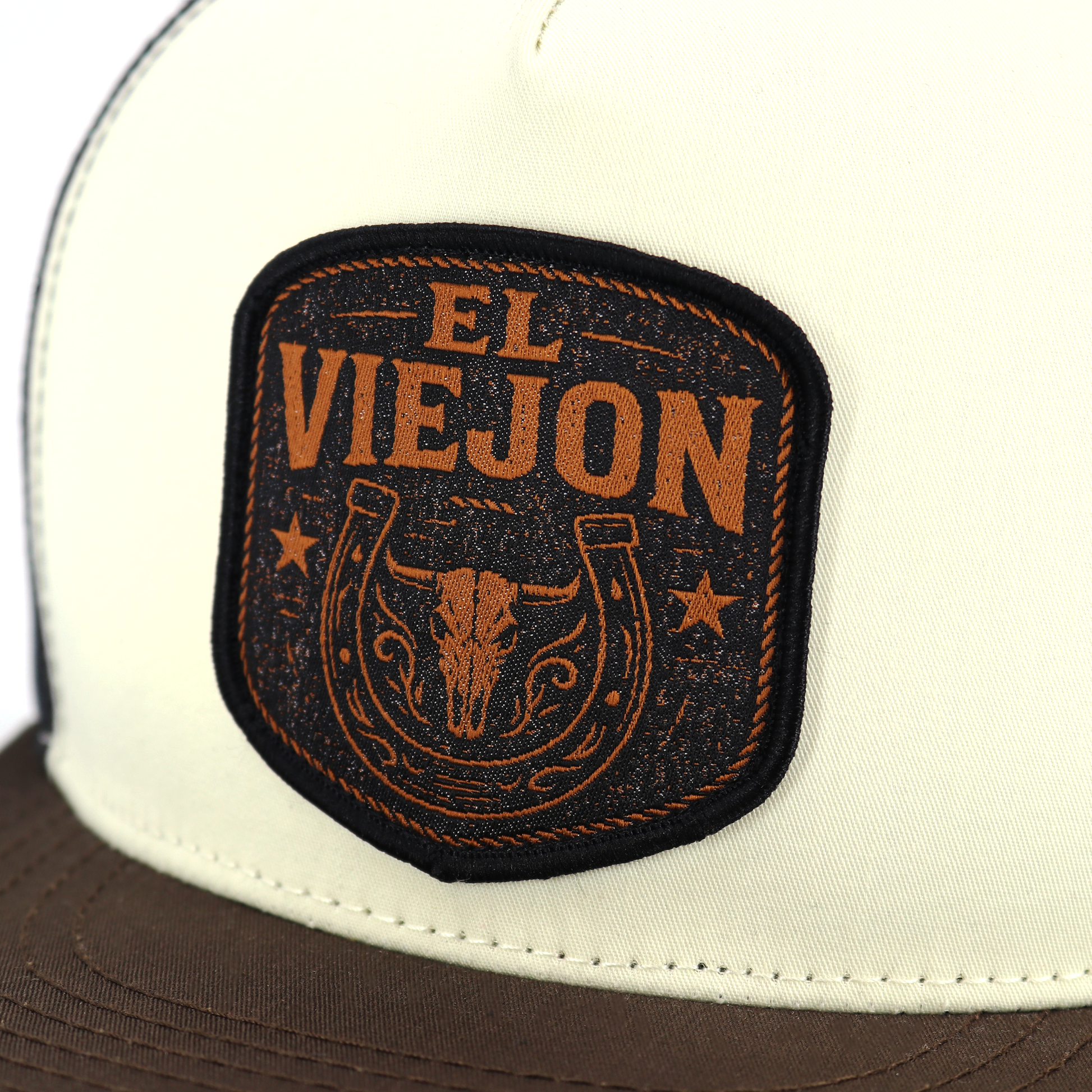 Rancho Viejo brown/cream/black flat visor hat with "EL VIEJON" patch, bull skull, and horseshoe design.