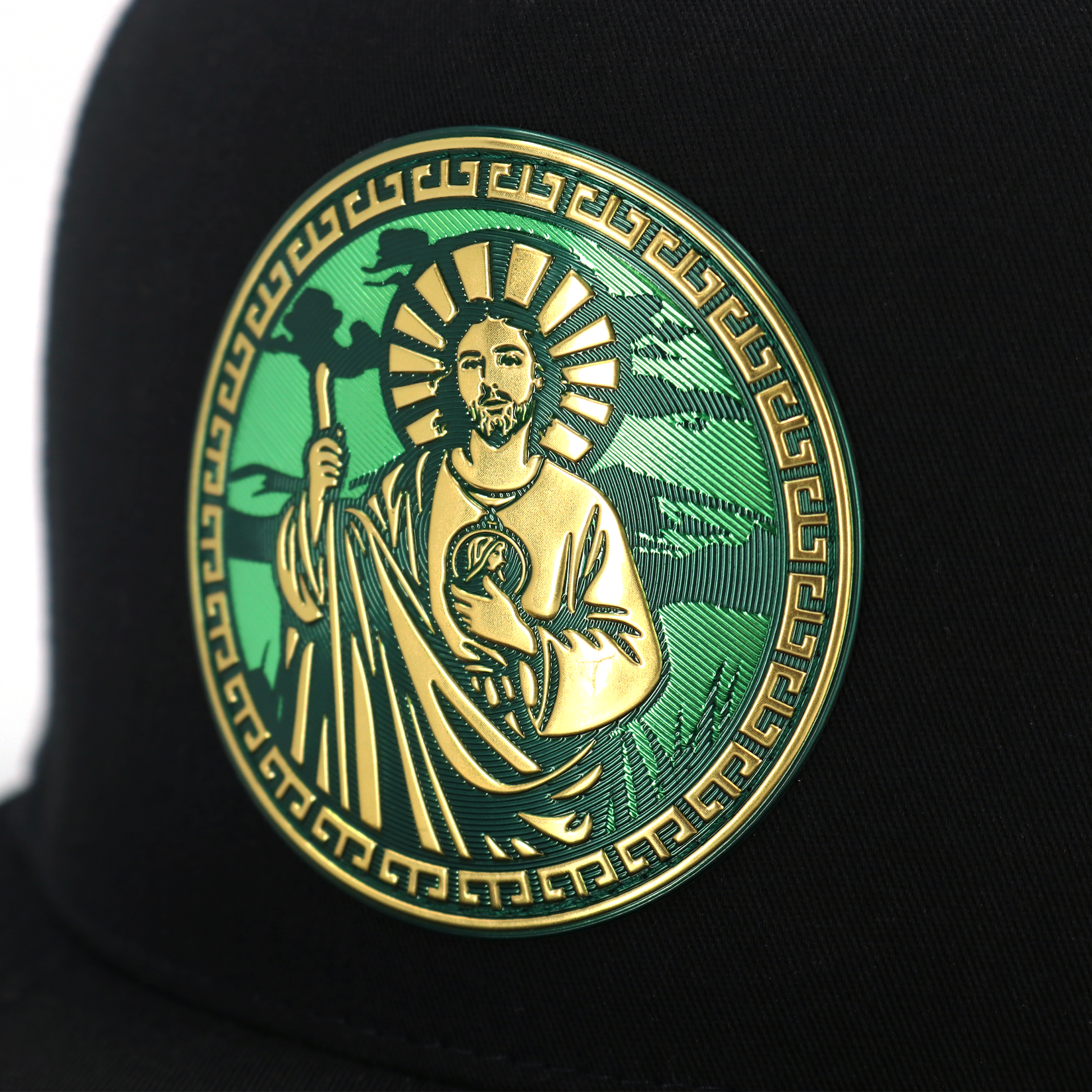 Black flat visor trucker hat with a gold and green San Judas Tadeo emblem.