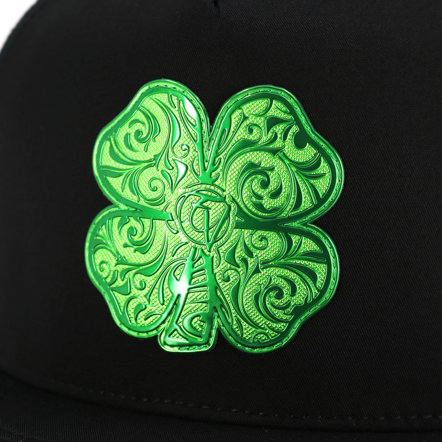 Black Trebol flat visor hat with a vibrant green, ornate four-leaf clover emblem.