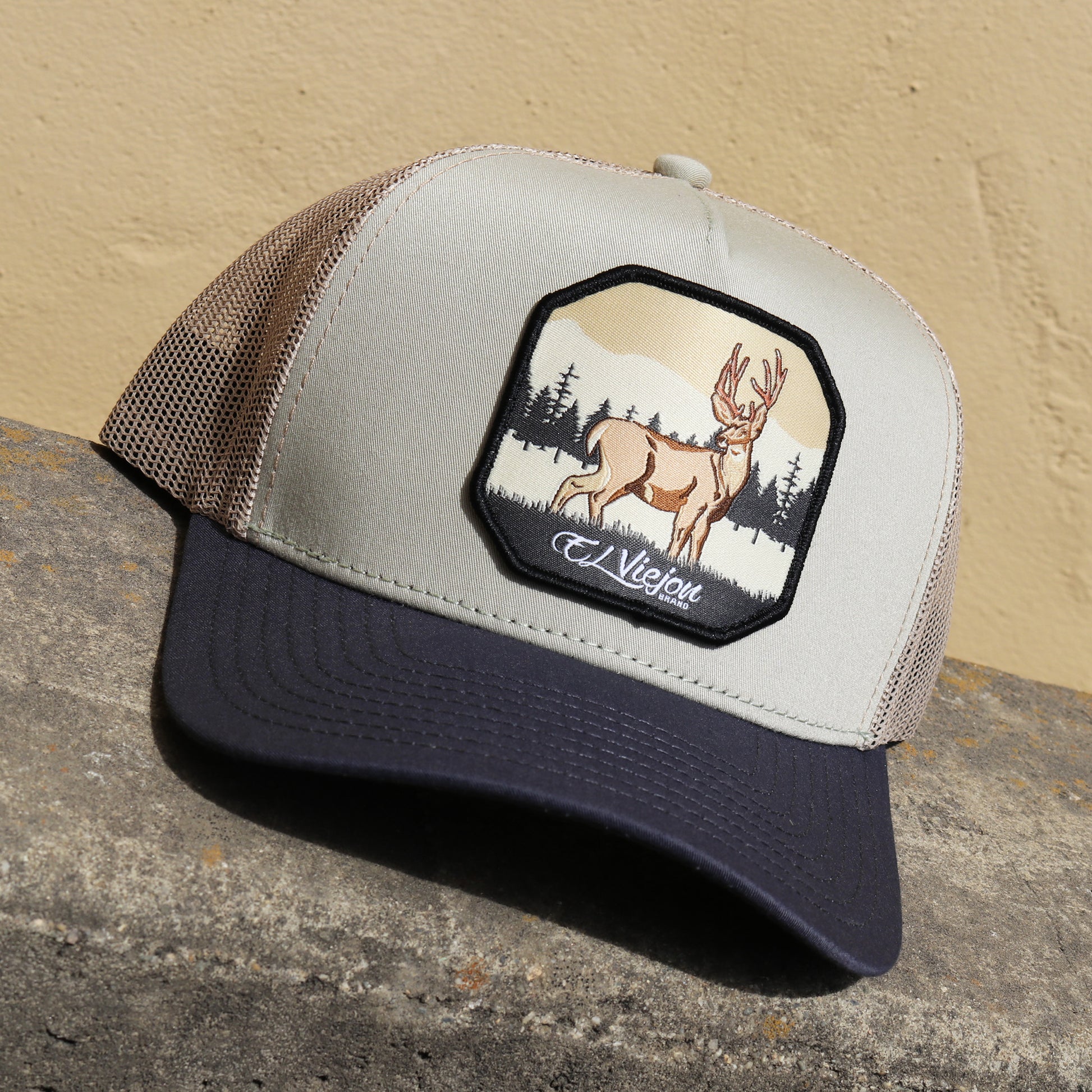 Venado Grey/Tope/Khaki AVC hat with a deer patch, high profile, pre-curved visor, and mesh back.