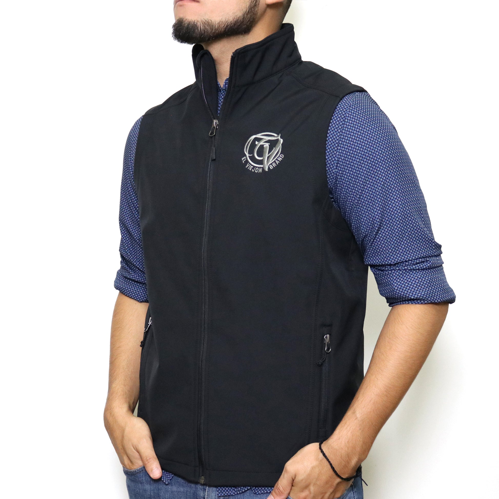 Black El Viejon Brand vest with charcoal logo, zip-through collar, and front zippered pockets.