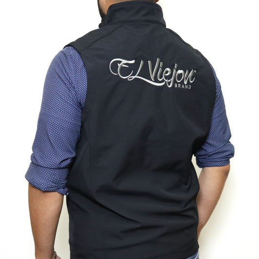 Black El Viejon Brand Vest, back view, with charcoal embroidered logo, worn over a blue patterned shirt.