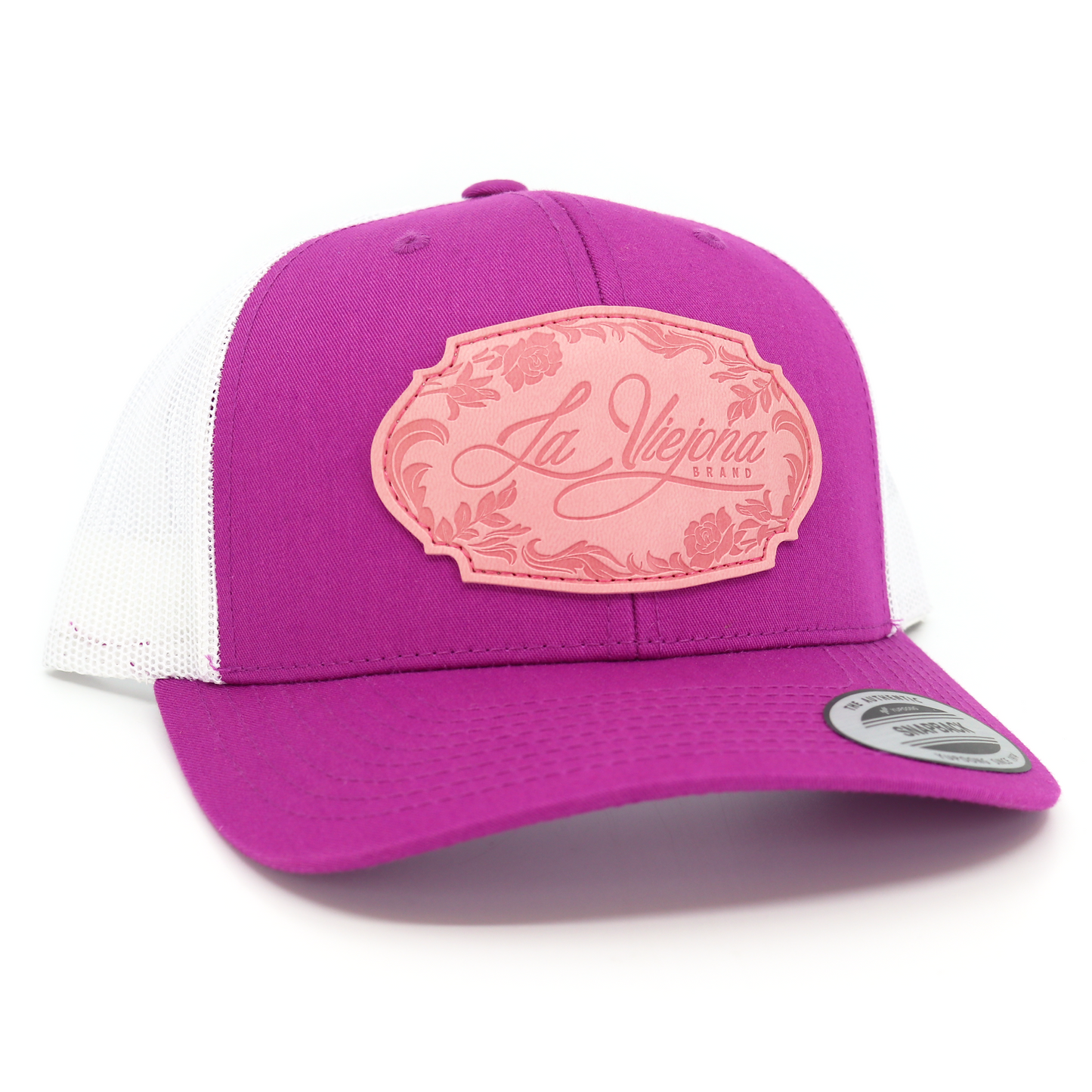 La Viejona magenta and white mesh trucker hat with a pink floral "La Viejona Brand" patch.