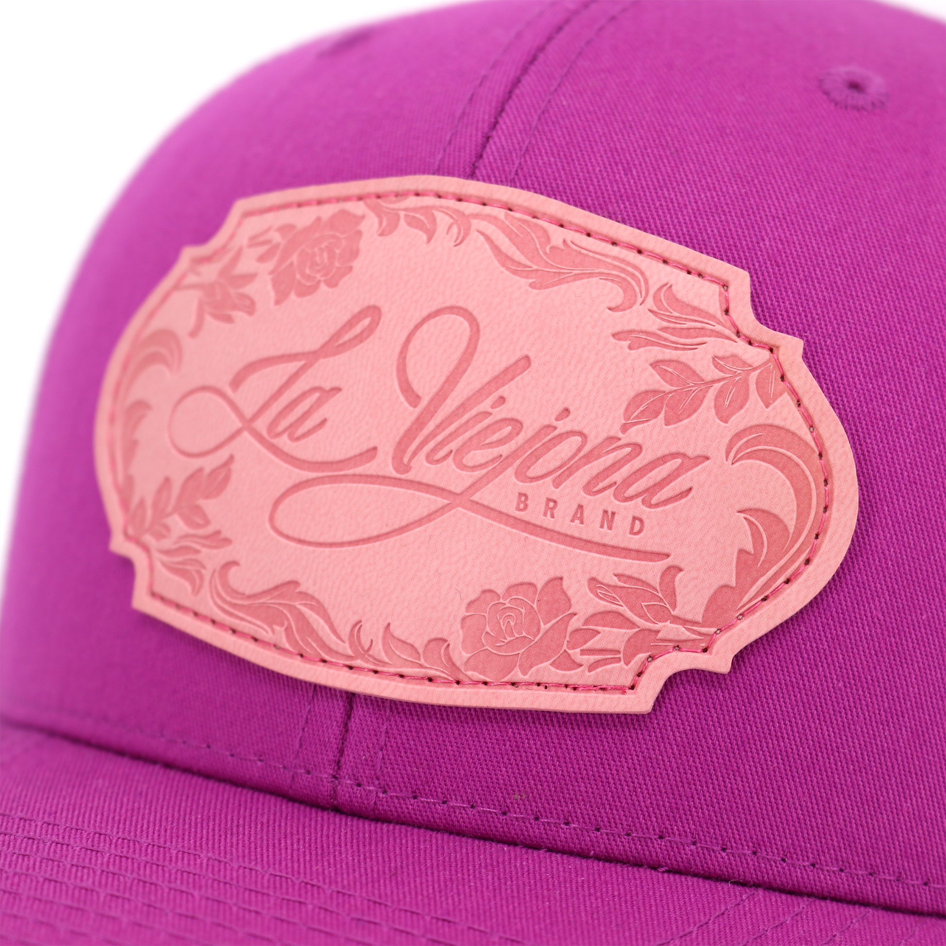 Magenta Yupoong trucker hat with a pink "La Viejona Brand" floral leather patch.