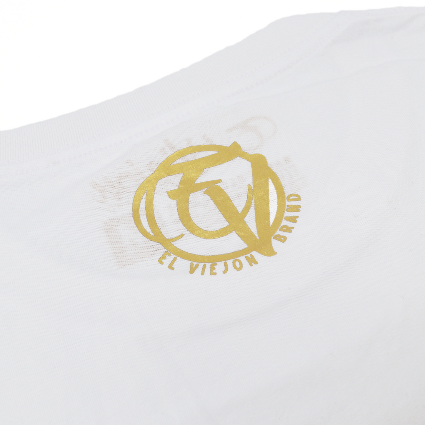 White 100% cotton Eminencia shirt with a gold screen-printed "El Viejon Brand" logo.