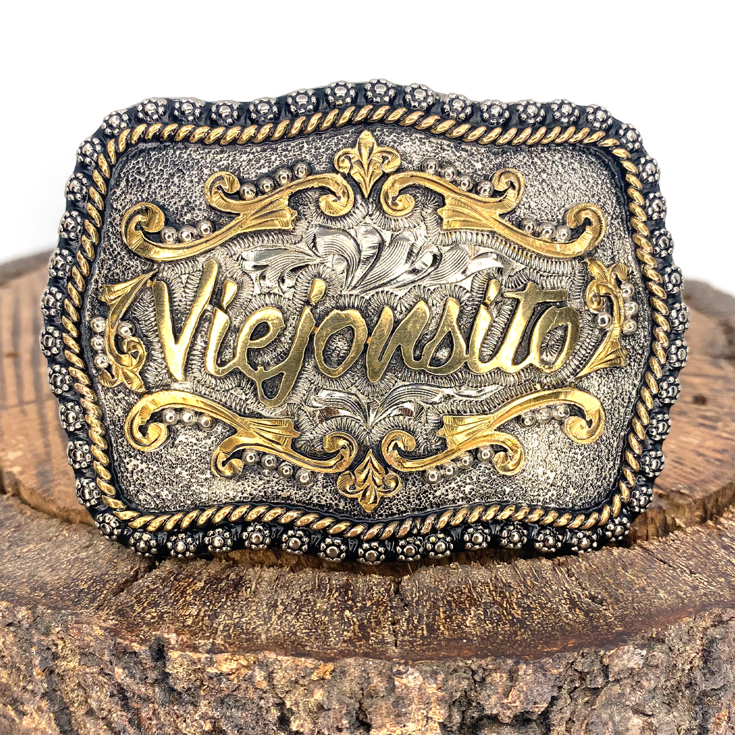 Hebilla artesanal "Viejonsito" para niño, de metal plateado y dorado con detalles grabados.