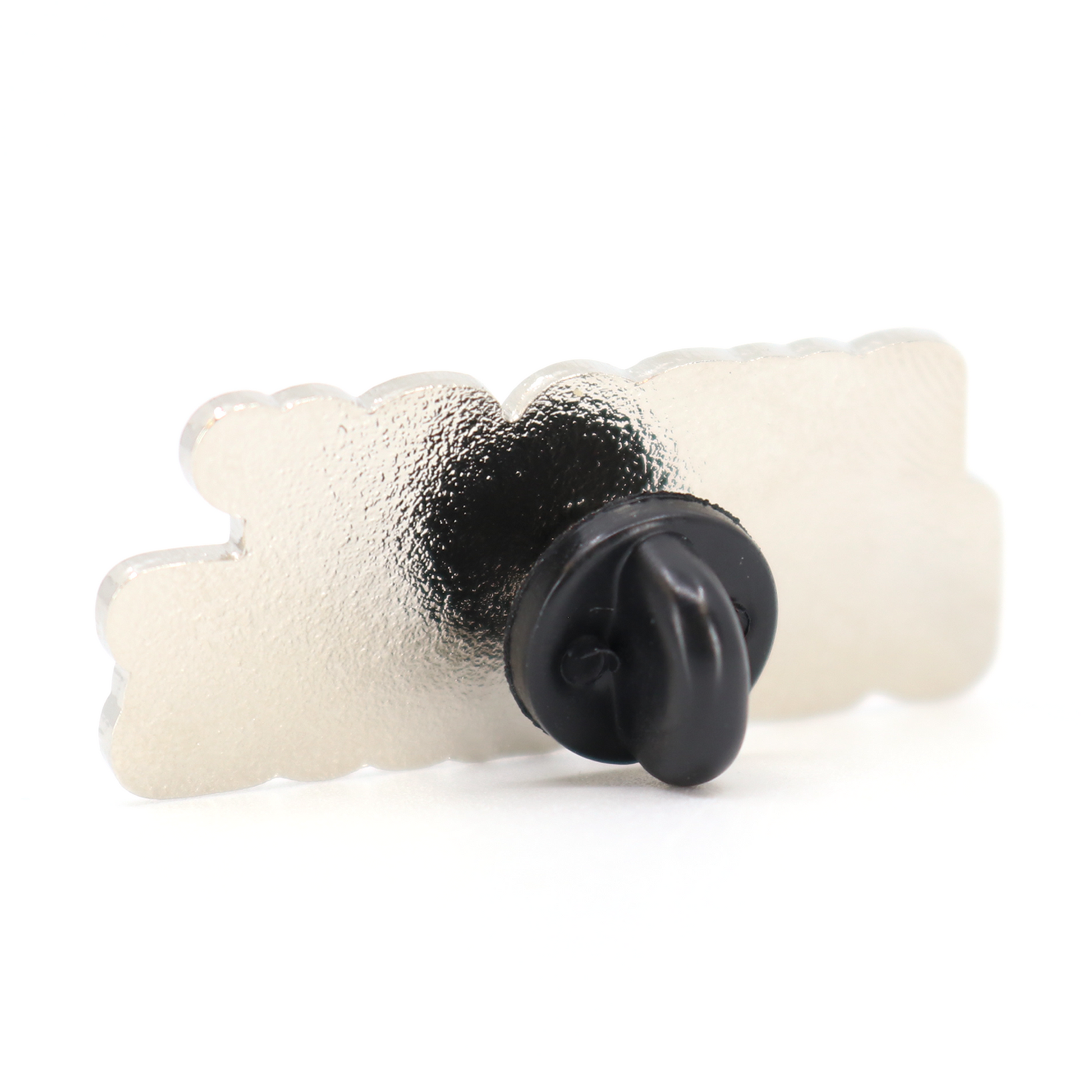Back of a rectangular white enamel Puro Pa Delante pin with a black rubber clutch.