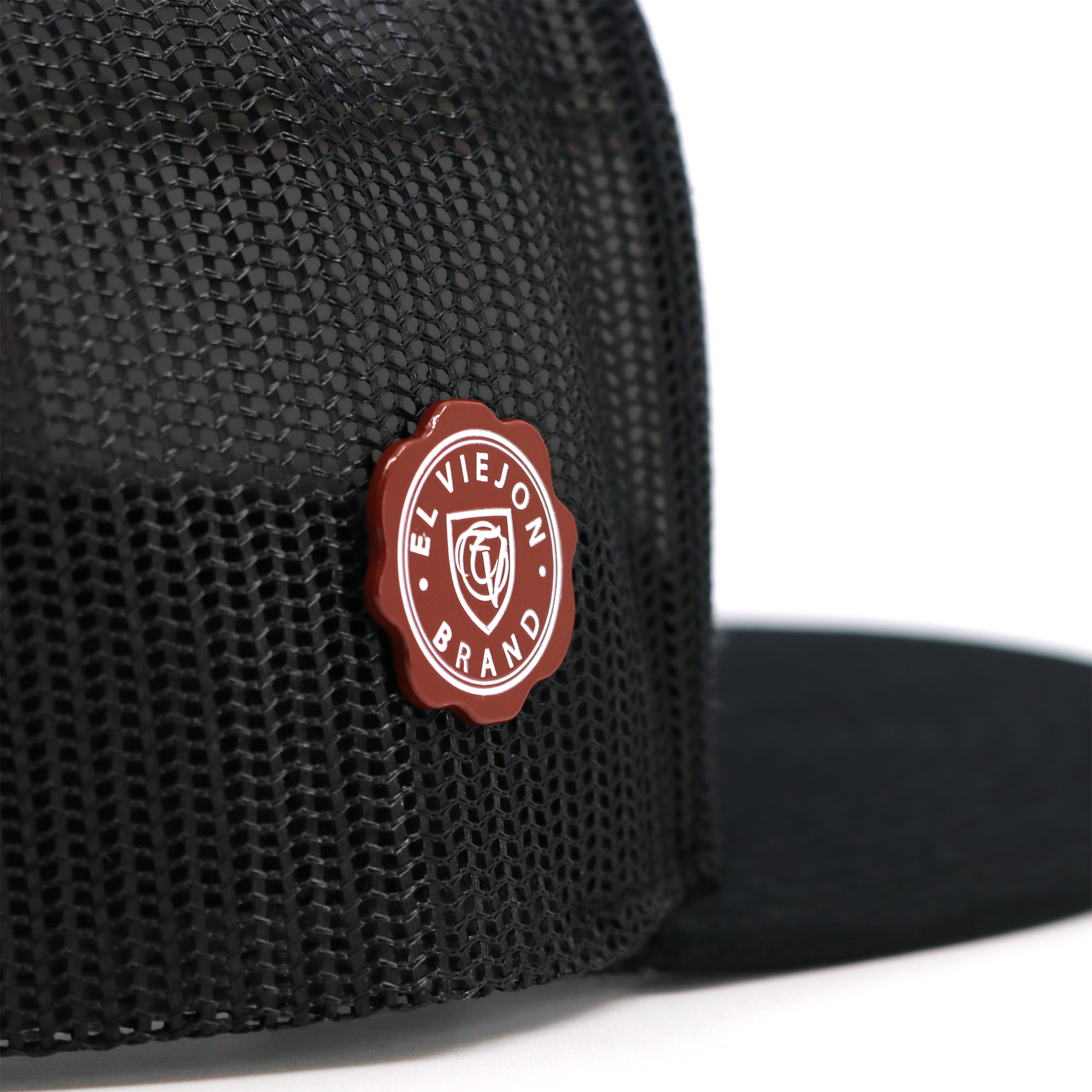 Sellito Rojo™ red and white enamel pin with "El Viejon Brand" text on a black mesh hat.